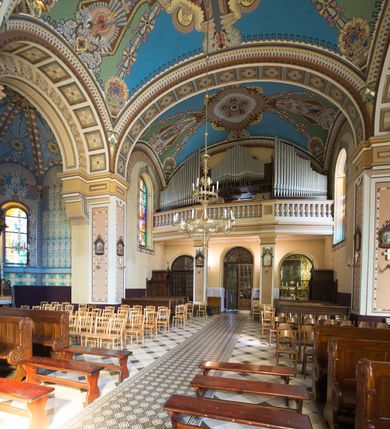 Zdjęcie nr 30: Kościół murowany, jednonawowy, z węższym prezbiterium zamkniętym trójbocznie oraz z wieżą wbudowaną w zachodnią fasadę. Do prezbiterium od północy przylega zakrystia, do nawy dwie kaplice leżące po przeciwległych stronach, zamknięte trójbocznie, od zachodu chór wsparty na dwóch filarach, z trójczęściową balustradą wychodzącą do przodu. Korpus trójprzęsłowy, przęsła oddzielone opilastrowanymi filarami podtrzymującymi arkady sklepienia. Nad kaplicami i prezbiterium fragmenty sklepienia gwiaździstego, nad nawą żaglaste. Wielobarwna polichromia  ścian i sklepień wypełnia podziały wyznaczone przez elementy architektoniczne, opiera się na motywach geometrycznych, stylizowanych floralnych, zoomorficznych i postaciach aniołów i świętych . Wszystkie okna w kształcie stojącego prostokąta zamkniętego półkoliście, w większości witraże, dwa w prezbiterium, po trzy z każdej strony nawy, po dwa w kaplicach, dwa na wysokości chóru, cztery w kondygnacji wieży; wyjątek stanowi okulus w fasadzie. Główne wejście przez fasadę, kolejne do zakrystii. Fasada dwukondygnacyjna, trójosiowa, na cokole, z wieżą. Osie wydzielone pilastrami, z których środkowa mieści drzwi o wykroju prostokąta i okulus w czworobocznej płycinie, a boczne zamknięte konchowo nisze w figurami św. Piotra po lewej i św. Pawła po prawej stronie. Kondygnacja zamknięta zdwojonym przyczółkiem. Wewnętrzny przerwany na kartusz herbowy i okrągłą plakietę z krzyżem, zewnętrzny na kondygnację wieży.  Wieża z każdej strony przepruta oknem zwieńczonym fragmentem gzymsu, na narożach ujęta pilastrami podtrzymującymi belkowanie z linią gzymsu wyoblającą się w środku i ujmującą tarczę zegara. Pozostałe elewacje na kamiennym cokole, nawa i prezbiterium z nietynkowanej cegły, kaplice i zakrystia otynkowane. Kontynuują podziały  pilastrami, artykulację podkreślają okna.  Dach nad nawą główną dwuspadowy, nad kaplicami i prezbiterium wieloboczne, wieża przekryta hełmem z latarnią, zwieńczona ostrosłupem z krzyżem.  
Najcenniejszym zabytkiem świątyni jest ołtarz główny z około 1700 roku przeniesiony tutaj z kościoła z Limanowej, interesująca jest polichromia o inspiracjach młodopolskich z elementami art  decó. 
