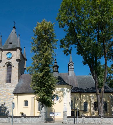 Zdjęcie nr 3: Kościół św. Andrzeja Apostoła w Szaflarach jest murowaną świątynią orientowaną. Składa się z czteroprzęsłowej nawy, przylegającego do niej od wschodu węższego, trójprzęsłowego prezbiterium zamkniętego łukiem spłaszczonym oraz czworobocznej wieży usytuowanej od zachodu. Po bokach nawy, na planie kwadratu ze ściętymi narożami, wzniesiono naprzeciw siebie dwie kaplice boczne, otwarte do wnętrza kościoła półokrągłymi arkadami. Od wschodu do kaplicy Najświętszego Serca Pana Jezusa przylega niewielka kruchta. Z kolei po stronie północnej prezbiterium wzniesiono na planie prostokąta zakrystię, poprzedzoną przedsionkiem i aneksem łączącym ją z kaplicą boczną Matki Boskiej, nad którym znajduje się skarbczyk. Prezbiterium doświetlone zostało przez trzy półokrągłe okna w ścianie południowej. Nawa, opięta na zewnątrz przyporami, została nakryta sklepieniem żaglastym z gurtami, a jej wnętrze, podobnie jak w prezbiterium, rozczłonkowano półfilarami. Zarówno nawę jak i prezbiterium nakryto dachem siodłowym, pokrytym blachą miedzianą. Obie kaplice boczne zasklepiono ośmiodzielnym sklepieniem i przykryto dachem namiotowym, wieńcząc go wielobocznymi latarniami z krzyżem. Doświetlają je półokrągłe okna oraz okulus, umieszczony w ścianie ołtarzowej, zamurowany w kaplicy Najświętszego Serca Pana Jezusa i od zewnątrz wypełniony współczesną mozaiką z wyobrażeniem Chrystusa Pantokratora. Elewacje prezbiterium, nawy i kaplic potynkowano. Od strony zachodniej do nawy przylega dwupoziomowa, czworoboczna wieża. Jej ściany olicowano okładziną z piaskowca. Dolny poziom wieży wyznacza nieznaczny uskok. Tu w przyziemiu urządzono kruchtę, do której prowadzi półokrągły portal. Nad portalem widoczny jest okulus. Górny poziom przepruto z trzech stron półokrągłymi oknami wypełnionymi drewnianymi żaluzjami. Wieżę zwieńczono ostrosłupowym hełmem, pokrytym blachą miedzianą i zakończonym krzyżem, który wspiera się na profilowanym gzymsie koronującym. Zwieńczenie wieży zostało wzbogacone w narożach czterema nadwieszonymi na wspornikach wielobocznymi wieżyczkami z ostrosłupowymi hełmami, pomiędzy którymi z trzech stron umieszczono tarcze zegarowe.