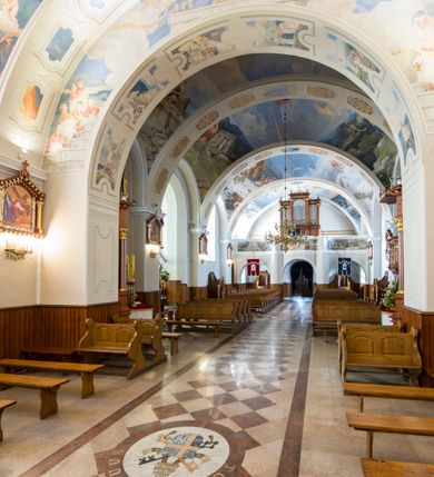 Zdjęcie nr 16: Kościół św. Andrzeja Apostoła w Szaflarach jest murowaną świątynią orientowaną. Składa się z czteroprzęsłowej nawy, przylegającego do niej od wschodu węższego, trójprzęsłowego prezbiterium zamkniętego łukiem spłaszczonym oraz czworobocznej wieży usytuowanej od zachodu. Po bokach nawy, na planie kwadratu ze ściętymi narożami, wzniesiono naprzeciw siebie dwie kaplice boczne, otwarte do wnętrza kościoła półokrągłymi arkadami. Od wschodu do kaplicy Najświętszego Serca Pana Jezusa przylega niewielka kruchta. Z kolei po stronie północnej prezbiterium wzniesiono na planie prostokąta zakrystię, poprzedzoną przedsionkiem i aneksem łączącym ją z kaplicą boczną Matki Boskiej, nad którym znajduje się skarbczyk. Prezbiterium doświetlone zostało przez trzy półokrągłe okna w ścianie południowej. Nawa, opięta na zewnątrz przyporami, została nakryta sklepieniem żaglastym z gurtami, a jej wnętrze, podobnie jak w prezbiterium, rozczłonkowano półfilarami. Zarówno nawę jak i prezbiterium nakryto dachem siodłowym, pokrytym blachą miedzianą. Obie kaplice boczne zasklepiono ośmiodzielnym sklepieniem i przykryto dachem namiotowym, wieńcząc go wielobocznymi latarniami z krzyżem. Doświetlają je półokrągłe okna oraz okulus, umieszczony w ścianie ołtarzowej, zamurowany w kaplicy Najświętszego Serca Pana Jezusa i od zewnątrz wypełniony współczesną mozaiką z wyobrażeniem Chrystusa Pantokratora. Elewacje prezbiterium, nawy i kaplic potynkowano. Od strony zachodniej do nawy przylega dwupoziomowa, czworoboczna wieża. Jej ściany olicowano okładziną z piaskowca. Dolny poziom wieży wyznacza nieznaczny uskok. Tu w przyziemiu urządzono kruchtę, do której prowadzi półokrągły portal. Nad portalem widoczny jest okulus. Górny poziom przepruto z trzech stron półokrągłymi oknami wypełnionymi drewnianymi żaluzjami. Wieżę zwieńczono ostrosłupowym hełmem, pokrytym blachą miedzianą i zakończonym krzyżem, który wspiera się na profilowanym gzymsie koronującym. Zwieńczenie wieży zostało wzbogacone w narożach czterema nadwieszonymi na wspornikach wielobocznymi wieżyczkami z ostrosłupowymi hełmami, pomiędzy którymi z trzech stron umieszczono tarcze zegarowe.