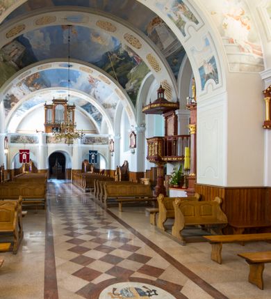 Zdjęcie nr 15: Kościół św. Andrzeja Apostoła w Szaflarach jest murowaną świątynią orientowaną. Składa się z czteroprzęsłowej nawy, przylegającego do niej od wschodu węższego, trójprzęsłowego prezbiterium zamkniętego łukiem spłaszczonym oraz czworobocznej wieży usytuowanej od zachodu. Po bokach nawy, na planie kwadratu ze ściętymi narożami, wzniesiono naprzeciw siebie dwie kaplice boczne, otwarte do wnętrza kościoła półokrągłymi arkadami. Od wschodu do kaplicy Najświętszego Serca Pana Jezusa przylega niewielka kruchta. Z kolei po stronie północnej prezbiterium wzniesiono na planie prostokąta zakrystię, poprzedzoną przedsionkiem i aneksem łączącym ją z kaplicą boczną Matki Boskiej, nad którym znajduje się skarbczyk. Prezbiterium doświetlone zostało przez trzy półokrągłe okna w ścianie południowej. Nawa, opięta na zewnątrz przyporami, została nakryta sklepieniem żaglastym z gurtami, a jej wnętrze, podobnie jak w prezbiterium, rozczłonkowano półfilarami. Zarówno nawę jak i prezbiterium nakryto dachem siodłowym, pokrytym blachą miedzianą. Obie kaplice boczne zasklepiono ośmiodzielnym sklepieniem i przykryto dachem namiotowym, wieńcząc go wielobocznymi latarniami z krzyżem. Doświetlają je półokrągłe okna oraz okulus, umieszczony w ścianie ołtarzowej, zamurowany w kaplicy Najświętszego Serca Pana Jezusa i od zewnątrz wypełniony współczesną mozaiką z wyobrażeniem Chrystusa Pantokratora. Elewacje prezbiterium, nawy i kaplic potynkowano. Od strony zachodniej do nawy przylega dwupoziomowa, czworoboczna wieża. Jej ściany olicowano okładziną z piaskowca. Dolny poziom wieży wyznacza nieznaczny uskok. Tu w przyziemiu urządzono kruchtę, do której prowadzi półokrągły portal. Nad portalem widoczny jest okulus. Górny poziom przepruto z trzech stron półokrągłymi oknami wypełnionymi drewnianymi żaluzjami. Wieżę zwieńczono ostrosłupowym hełmem, pokrytym blachą miedzianą i zakończonym krzyżem, który wspiera się na profilowanym gzymsie koronującym. Zwieńczenie wieży zostało wzbogacone w narożach czterema nadwieszonymi na wspornikach wielobocznymi wieżyczkami z ostrosłupowymi hełmami, pomiędzy którymi z trzech stron umieszczono tarcze zegarowe.