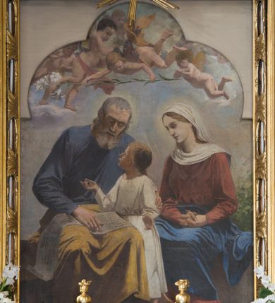 Zdjęcie nr 15: Nastawa ołtarzowa jednoosiowa, jednokondygnacyjna ze zwieńczeniem, ustawiona na wysokim dwustrefowym cokole, zryzalitowanym na zewnetrznych krawędziach. Ołtarz prostopadłościenny z kamienną mensą. Antepedium drewniane, dekorowane na wybrzuszeniu trzema płycinami z rytą wicią roślinną i monogramem IHS. Tabernakulum w kształcie kapliczki na cokole w formie prostopadłościanu; ścianka frontowa ujęta półfilarami dźwigającymi gzyms opasujący go z trzech stron, na froncie przyjmujący kształt łuku segmentowego, spiętego ustawionymi przeciwstawnie wolutami. Trzony półfilarów dekorowane owocowo-roślinnymi zwisami, pole środkowe skręconymi liśćmi akantu w układzie lustrzanym. Na nim nastawa w formie półokrągłej ścianki dekorowanej płyciną w kształcie stojącego prostokąta zamkniętego łukiem pełnym zdobionym kielichem z unoszącą się ponad nim hostią w otoczeniu promieni. Drzwiczki ujęte skręconymi kolumnami dźwigającymi pełne belkowanie wyłamane na ich osiach i wyniesione w łuk na polem centralnym. Na środku fryzu uskrzydlona główka anielska. Na wyłamanych częściach belkowania wazony płomieniste. Nastawa ołtarzowa ujęta parą kolumn o kapitelach kompozytowych dźwigających fragmenty belkowania o silnie wysuniętym gzymsie, połączone architrawem przyjmującym nad polem środkowym kształt łuku pełnego. Pole środkowe niemal w całości wypełnia nisza ujęta ramą w formie stojącego prostokąta wyłamanego prostokątnie w partii górnego boku, wypełniona obrazem św. Rodziny wymiennie z wizerunkiem Matki Boskiej Niepokalanie Poczętej. Zwieńczenie na zwężającej się łukowato podstawie w formie przyczółka przerwanego pośrodku cokołem z krzyżem. Cokół w górnej strefie dekorowany płycinami, w partii ryzalitów wypełnionymi akantem mięsistym i uskrzydloną główką anielską na froncie. Rama obrazu w polu środkowym dekorowana wstęgą i liśćmi; w prostokątnym polu nad obrazem płaskorzeźbione obłoki z rzeźbą Gołębicy Ducha Świętego w glorii; powyżej w polu łuku półpostać Boga Ojca z rozłożonymi na boki rękami. Kondygnacja ujęta uszakami utworzonymi z silnie skręcanego mięsistego akantu, zwiniętego w woluty oraz guzy. Krawędzie podstawy zwieńczenia oraz gzyms przyczółka dekorowane liśćmi akantu. Struktura polichromowana w kolorze kremowym; ornamentyka, profile i kolumny złocone i srebrzone.