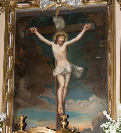 Zdjęcie nr 6: Nastawa ołtarzowa jednoosiowa, jednokondygnacyjna ze zwieńczeniem, ustawiona na wysokim dwustrefowym cokole, zryzalitowanym na zewnetrznych krawędziach. Ołtarz prostopadłościenny z kamienną mensą. Antepedium drewniane, dekorowane na wybrzuszeniu trzema płycinami z rytą wicią roślinną i monogramem IHS. Tabernakulum w kształcie kapliczki na cokole w formie prostopadłościanu; ścianka frontowa ujęta półfilarami dźwigającymi gzyms opasujący go z trzech stron, na froncie przyjmujący kształt łuku segmentowego, spiętego ustawionymi przeciwstawnie wolutami. Trzony półfilarów dekorowane owocowo-roślinnymi zwisami, pole środkowe skręconymi liśćmi akantu w układzie lustrzanym. Na nim nastawa w formie półokrągłej ścianki dekorowanej płyciną w kształcie stojącego prostokąta zamkniętego łukiem pełnym zdobionym kielichem z unoszącą się ponad nim hostią w otoczeniu promieni. Drzwiczki ujęte skręconymi kolumnami dźwigającymi pełne belkowanie wyłamane na ich osiach i wyniesione w łuk na polem centralnym. Na środku fryzu uskrzydlona główka anielska. Na wyłamanych częściach belkowania wazony płomieniste. Nastawa ołtarzowa ujęta parą kolumn o kapitelach kompozytowych dźwigających fragmenty belkowania o silnie wysuniętym gzymsie, połączone architrawem przyjmującym nad polem środkowym kształt łuku pełnego. Pole środkowe niemal w całości wypełnia nisza ujęta ramą w formie stojącego prostokąta wyłamanego prostokątnie w partii górnego boku, wypełniona obrazem św. Rodziny wymiennie z wizerunkiem Matki Boskiej Niepokalanie Poczętej. Zwieńczenie na zwężającej się łukowato podstawie w formie przyczółka przerwanego pośrodku cokołem z krzyżem. Cokół w górnej strefie dekorowany płycinami, w partii ryzalitów wypełnionymi akantem mięsistym i uskrzydloną główką anielską na froncie. Rama obrazu w polu środkowym dekorowana wstęgą i liśćmi; w prostokątnym polu nad obrazem płaskorzeźbione obłoki z rzeźbą Gołębicy Ducha Świętego w glorii; powyżej w polu łuku półpostać Boga Ojca z rozłożonymi na boki rękami. Kondygnacja ujęta uszakami utworzonymi z silnie skręcanego mięsistego akantu, zwiniętego w woluty oraz guzy. Krawędzie podstawy zwieńczenia oraz gzyms przyczółka dekorowane liśćmi akantu. Struktura polichromowana w kolorze kremowym; ornamentyka, profile i kolumny złocone i srebrzone.