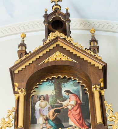 Zdjęcie nr 7: Przyścienny trójosiowy, jednokondygnacyjny ołtarz architektoniczny ustawiono na dwustopniowym podeście. Stipes ołtarzowy flankowany przez dwie złocone kolumienki wspierające mensę, ozdobiono trzema płycinami zamkniętymi łukiem odcinkowym. Pola skrajne płycin wypełnia romboidalny czworobok wpisany w owal. Jego wnętrze dekoruje ornamentyka geometryczno-roślinna. Pole środkowe ozdobiono kwadratem wpisanym w owal, w środku którego umieszczono krzyż równoramienny w promienistym otoku. Na mensie ustawiono czworoboczne tabernakulum zwieńczone baldachimem. Front tabernakulum flankują dwie, smukłe, złocone kolumienki o korynckich kapitelach podtrzymujące spłaszczony łuk odcinkowy. Srebrzone półokrągłe drzwiczki wpisano w prostokątne obramienie dekorowane w narożach złoconymi rozetkami. Na drzwiczkach umieszczono chrystogram "IHS" ponad kłosami i winnym gronem. Baldachim tabernakulum uzyskał formę ażurowej, czworobocznej kapliczki o półkoliście zamkniętych, prostokątnych ściankach z wpisanym w górnej części trójliściem. W jej narożach umieszczono kolumienki na wysokich postumentach z kapitelami kostkowymi. Trójosiowe retabulum wsparto na wysokim postumencie, flankowanym przez nieznacznie wysunięte smukłe podpory, dekorowane od frontu płaskorzeźbionym ornamentem roślinnym. Na nich wspierają się skrajne kolumienki, zamykające partię cokołową nastawy. Artykułują je dwie edikule w skrajnych osiach zamknięte łukiem odcinkowym, ozdobionym płaskorzeźbionym ornamentem roślinnym. Wnętrze edikul wypełnia złocona kratownica z polami zdobionymi motywem stylizowanego krzyżyka. Ponad nimi widoczny jest fryz arkadkowy. Na osi środkowej umieszczono prostokątną, półkoliście zamknietą wnękę o konsze dekorowanej stylizowanymi kasetonami. W niej ustawiono stojacą figurę Najświętszego Serca Pana Jezusa. Wnękę flankują dwie złocone kolumny o kapitelach kostkowych i trzonach zdobionych pierścieniami. Podtrzymują one nadbudowę ze zwieńczeniem zakończonym latarnią. Nadbudowę u góry zamknięto nadwieszonym łukiem odcinkowym. Po bokach flankują ją dwie złocone kolumienki o korynckich kapitelach. Pomiędzy kolumnami widoczny jest fryz arkadowy z umieszczoną na środku złoconą rozetą. Łuk w górnej partii udekorowano złoconą koronką oraz znajdującymi się po bokach dwiema, wielobocznymi sterczynami. Zwieńczenie uzyskało kształt płaskiej kapliczki o dwuspadowym dachu z prostokątnym, półkoliście zamkniętym polem środkowym flankowanym parą kolumienek. Pole dekorowane arkaturą wypełnia obraz "Powrót syna Marnotrawnego". Na dachu kapliczki ustawiono na osi ażurową latarnię a po jej bokach wieloboczne sterczyny. Ponad skrajnymi edikulami w osiach bocznych w partii cokołowej usytuowano płyciny zamknięte po bokach złoconymi kolumienkami z kapitelami kostkowymi, o trzonach dekorowanych pierścieniami, podtrzymujące trójkątne, nadwieszone przyczółki. Zdobi je złocona koronka oraz motyw fryzu arkadkowego. Nad przyczółkami ustawiono zwieńczenie w formie płaskiej kapliczki o półkoliście zamkniętym, ażurowym wykroju wypełnionym złoconym, ornamentem roślinnym z latarenką. Prostokątne płyciny dekorowane w górnej części stylizowanym maswerkiem zawierają płaskorzeźbione przedstawienia. Z lewej strony wyobrażono Chrystusa jako Dobrego Pasterza, a z prawej cudowne rozmnożenie chleba.             