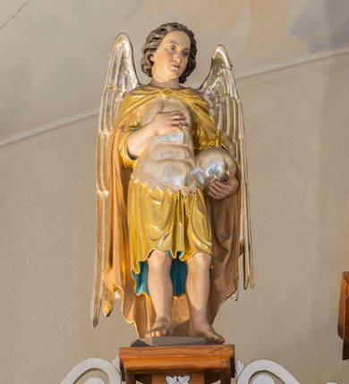 Zdjęcie nr 6: Przyścienną nastawę architektoniczną, trójosiową wykonano z drewna modrzewiowego. Jest to konstrukcja jednokondygnacyjna ze zwieńczeniem, w formie łuku triumfalnego, ustawiona na dwustrefowym cokole. Oś środkową wydzielają dwie pary kolumn o kapitelach kompozytowych i kanelowanych trzonach dźwigających wydłużone imposty. Kolumny wewnętrzne zostały połączone nad polem środkowym fryzem i gzymsem. Z kolei kolumny zewnętrze podtrzymują belkowanie zwieńczenia. Pole środkowe wypełnia nisza w formie stojącego prostokąta zamkniętego łukiem półkolistym z arkaturą z obrazem św. Andrzeja Apostoła. W osiach zewnętrznych usytuowano niższe flankowane parą kanelowanych kolumn z kapitelami kompozytowymi podtrzymujących imposty połączone nad polem fryzem i gzymsem. Nisze uzyskały kształt stojącego prostokąta zamkniętego łukiem półkolistym z arkaturą z figurami św. Wincentego a Paulo i św. Jana Kantego. Ponad niszami na belkowaniu usytuowano cokoły z figurami aniołów trzymających insygnia królewskie. Zwieńczenie uzyskało kształt leżącego prostokąta flankowanego dwiema parami złoconych kolumienek, dźwigających imposty i gzyms nad polem środkowym wyłamanym w trójkąt. Po bokach widoczne są spływy wolutowe. W polu znajduje się rama w formie kwadratu z wpisanym kołem z płaskorzeźbionym przedstawieniem Trójcy Świętej. Cokoły i imposty dekorowane zostały stylizowaną ornamentyką roślinną w postaci zwisów, kampanuli i girland. Struktura nastawy utrzymana jest w kolorze naturalnego drewna, natomiast ornamentyka, detale i profile zostały wyzłocone i wysrebrzone. Z kolei figury i płaskorzeźba w zwieńczeniu uzyskały naturalistyczną polichromię.