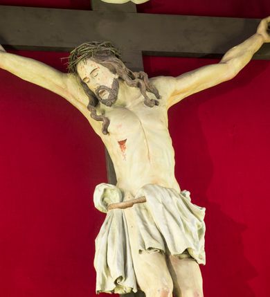 Zdjęcie nr 4: Przyścienną nastawę architektoniczną, trójosiową wykonano z drewna modrzewiowego. Jest to konstrukcja jednokondygnacyjna ze zwieńczeniem, w formie łuku triumfalnego, ustawiona na dwustrefowym cokole. Oś środkową wydzielają dwie pary kolumn o kapitelach kompozytowych i kanelowanych trzonach dźwigających wydłużone imposty. Kolumny wewnętrzne zostały połączone nad polem środkowym fryzem i gzymsem. Z kolei kolumny zewnętrze podtrzymują belkowanie zwieńczenia. Pole środkowe wypełnia nisza w formie stojącego prostokąta zamkniętego łukiem półkolistym z arkaturą z obrazem św. Andrzeja Apostoła. W osiach zewnętrznych usytuowano niższe flankowane parą kanelowanych kolumn z kapitelami kompozytowymi podtrzymujących imposty połączone nad polem fryzem i gzymsem. Nisze uzyskały kształt stojącego prostokąta zamkniętego łukiem półkolistym z arkaturą z figurami św. Wincentego a Paulo i św. Jana Kantego. Ponad niszami na belkowaniu usytuowano cokoły z figurami aniołów trzymających insygnia królewskie. Zwieńczenie uzyskało kształt leżącego prostokąta flankowanego dwiema parami złoconych kolumienek, dźwigających imposty i gzyms nad polem środkowym wyłamanym w trójkąt. Po bokach widoczne są spływy wolutowe. W polu znajduje się rama w formie kwadratu z wpisanym kołem z płaskorzeźbionym przedstawieniem Trójcy Świętej. Cokoły i imposty dekorowane zostały stylizowaną ornamentyką roślinną w postaci zwisów, kampanuli i girland. Struktura nastawy utrzymana jest w kolorze naturalnego drewna, natomiast ornamentyka, detale i profile zostały wyzłocone i wysrebrzone. Z kolei figury i płaskorzeźba w zwieńczeniu uzyskały naturalistyczną polichromię.