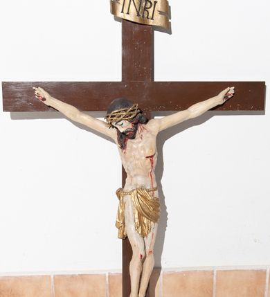 Zdjęcie nr 2: Rzeźba pełnoplastyczna, lekko ścięta z tyłu; z widocznym koluszkiem na plecach. Chrystus rozpięty na krzyżu w lekkim zwisie ciała, z szeroko rozłożonymi rękoma i nogami lekko ugiętymi w kolanach; stopy przybite jednym gwoździem, założone prawa na lewą. Ukazany jako martwy, z głową zwieszoną na prawy bark Twarz pociągła, z krótkim zarostem i długimi włosami spływającymi na plecy i na prawy bark. Ciało z podkreśloną budową anatomiczną i muskulaturą; w lewym boku rana. Na głowie korona cierniowa spleciona z trzech cienkich gałązek. Wokół bioder sznur podtrzymujący skąpe perizonium o formie pasa draperii. U góry, na pionowej belce krzyża umieszczony poziomo titulus o postrzępionych bokach, z literami INRI. Karnacja ciała w odcieniu naturalnym ze strużkami i kroplami krwi, włosy i zarost brązowe, titulus biały, korona cierniowa i perizonium pozłocone. 