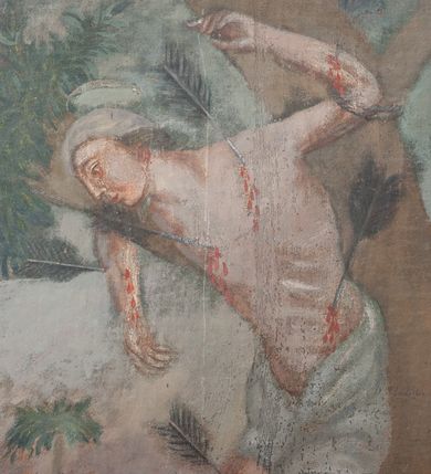 Zdjęcie nr 1: Obraz w kształcie stojącego prostokąta, malowany olejno na desce, w wąskiej drewnianej ramce, z przedstawieniem męczeństwa św. Sebastiana. Święty przedstawiony w całej postaci, zwrócony w prawo, stoi przywiązany do drzewa, oparty biodrami o pień, ze skrzyżowanymi nogami i z rękami wzniesionymi do góry. Ciało nagie, muskularne, o zaburzonych proporcjach; wokół bioder biała draperia przewiązana z przodu. W ciało wbite kilka dużych strzał. Po prawej stronie w głębi duża postać ludzka o ciemnych zwichrzonych włosach. W tle zarys pejzażu.