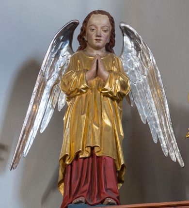 Zdjęcie nr 9: Przyścienną nastawę architektoniczną, trójosiową wykonano z drewna modrzewiowego. Jest to konstrukcja jednokondygnacyjna w formie łuku triumfalnego ze zwieńczeniem, ustawiona na dwustrefowym cokole. Stipes ołtarzowy uzyskał formę leżącego prostopadłościanu flankowanego po bokach spływami wolutowymi. W stipesie od przodu we wnęce pomiędzy dwoma pilastrami podtrzymującymi mensę umieszczono płaskorzeźbę z przedstawieniem odnoszącym się najprawdopodobniej do życia proroka Jonasza. Trzony pilastrów ozdobiono płaskorzeźbionym i złoconym ornamentem roślinnym. Oś środkową nastawy wydzielają dwie kolumny o kapitelach korynckich i kanelowanych trzonach dźwigających wydłużone imposty. Kolumny zostały połączone nad polem środkowym fryzem i gzymsem. Pole środkowe wypełnia nisza w formie stojącego prostokąta zamkniętego łukiem półkolistym z arkaturą z półkoliście zamkniętym obrazem Matki Boskiej Częstochowskiej. Na zasuwie umieszczono obraz św. Franciszka z Asyżu. W osiach zewnętrznych usytuowano niższe flankowane kanelowanymi kolumnami z kapitelami kompozytowymi, podtrzymującymi imposty połączone nad polem fryzem i gzymsem. Nisze uzyskały kształt stojącego prostokąta zamkniętego łukiem półkolistym z arkaturą z figurami św. Wojciecha i św. Stanisława. Ponad niszami na belkowaniu usytuowano cokoły z figurami stojących aniołów ze złożonymi do modlitwy rękami. Zwieńczenie uzyskało kształt stojącego prostokąta flankowanego dwiema parami złoconych kolumienek, dźwigających imposty i gzyms nad polem środkowym wyłamanym w trójkąt. Po bokach widoczne są spływy wolutowe. Gzyms wieńczy krzyż i dwie złocone wazy. W polu zwieńczenia znajduje się rama w formie prostokąta z wpisanym owalem z obrazem św. Bartłomieja Apostoła. Ponad ramą widoczny jest monogram maryjny. Cokoły i imposty dekorowane zostały stylizowaną ornamentyką roślinną w postaci zwisów, kampanuli i girland. Struktura nastawy utrzymana jest w kolorze naturalnego drewna, natomiast ornamentyka, detale i profile zostały wyzłocone i wysrebrzone. Z kolei figury uzyskały naturalistyczną polichromię.