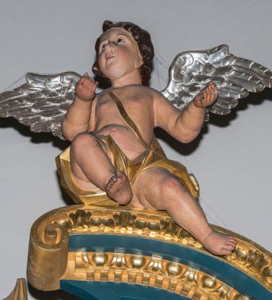 Zdjęcie nr 10: Ołtarz w kaplicy Matki Boskiej Szaflarskiej stanowi przykład przyściennej, architektonicznej, drewnianej nastawy trójosiowej ze zwieńczeniem. Stipes ołtarzowy z drewnianą mensą z kamiennym portatylem uzyskał kształt leżącego prostopadłościanu. Jego przód flankują hermy o trzonach dekorowanych cekinami. W polu zastosowano prostokątną płycinę ujętą kimationem. Na mensie ustawiono prostopadłościenne tabernakulum z wyodrębnionym cokołem i gzymsem koronującym wyłamanym na osi, podtrzymywanym przez dwa pilastry. Krawędzie tabernakulum zdobi imitacja boniowania. Drzwiczki ozdobiono stojącą, prostokątną płyciną, zwieńczoną trójkątnym przyczółkiem. W polu płyciny umieszczono stojący na obłokach płaskorzeźbiony i złocony kielich z hostią otoczoną promieniami. Jednokondygnacyjna nastawa wspiera się na prostokątnej predelli, przechodzącej pod osiami bocznymi w wolutowe konsole. Osie retabulum wydzielone zostały za pomocą skrajnych pilastrów oraz pary kolumn flankujących oś środkową. Podpory dźwigają pełne belkowanie wyłamane na ich osi, przerwane w partii pola środkowego oraz na osiach skrajnych przerwany półokrągły przyczółek. Wewnętrzna para kolumn dźwiga dodatkowo parę konsol podtrzymujących pełne belkowanie wyłamane na ich osi. Zwieńczenie uzyskało formę kwadratu zamkniętego szczytem z krzyżem, ujętego parą kolumienek na cokołach podtrzymujących skrajne woluty. Po zewnętrznych bokach zwieńczenia usytuowano postacie adorujących aniołów. W polu środkowym kondygnacji znalazła się nisza w formie stojącego prostokąta zamkniętego archiwoltą opadającą na belkowanie z konchą wydzieloną przez poziomy gzyms wsparty na dwóch pilastrach. W podniebiu konchy widoczna jest rzeźbiona i srebrzona gołębica Ducha Świętego. W niszy ustawiono figurę Matki Boskiej z Dzieciątkiem stojącą na wysokim czworobocznym postumencie. W osiach bocznych znalazły się nisze zamknięte konchą, u dołu podtrzymywane wspornikiem, z figurami św. Elżbiety Węgierskiej i św. Kazimierza Królewicza. W polu zwieńczenia umieszczono obraz w formie owalu ujęty ramą z przedstawieniem św. Maurycego. Ołtarz w całości pokryty został bogatą i zróżnicowaną dekoracją ornamentalną. Liśćmi akantu ozdobiono cokoły kolumn i wolut podwieszonych pod boczne osie. Kolumny w jednej czwartej wysokości obwiedzione zostały profilowaną listwą wypełnioną rautami. Ich dolne części ozdobiono uskrzydlonymi główkami aniołów z podwieszonymi festonami i girlandami. Z kolei w górnych partiach wykorzystano spiralne wici winnego grona. Dekoracyjnie artykułowano także pilastry, które w jednej czwartej przedzielono profilowanym gzymsem. Ich dolne części szczelnie wypełniono ornamentem okuciowym z rautem w środku, z kolei górne pokryto układającą się swobodnie i symetrycznie wstęgą z kaboszonami. Fryz belkowania wypełniony został wicią roślinną. Pola pomiędzy niszą a belkowaniem ozdobiono uskrzydlonymi główkami aniołów i podwieszonymi pod nimi girlandami. Ponadto uskrzydlone główki aniołów zdobią imposty podstawy zwieńczenia oraz klucz archiwolty ponad niszą główną. Kolumieńki zwieńczenia ozdobione zostały układającą się spiralnie wstęgą. Na dekoracje ornamentalną nastawy składają się również różne zdobienia profilów belkowania i zwieńczenia w postaci kostkowania, wolich oczu oraz pasów utworzonych z liści akantu.
