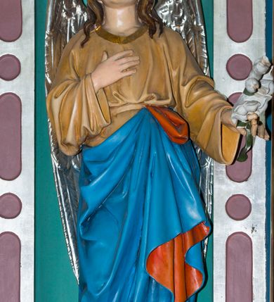 Zdjęcie nr 5: Ołtarz w kaplicy Matki Boskiej Szaflarskiej stanowi przykład przyściennej, architektonicznej, drewnianej nastawy trójosiowej ze zwieńczeniem. Stipes ołtarzowy z drewnianą mensą z kamiennym portatylem uzyskał kształt leżącego prostopadłościanu. Jego przód flankują hermy o trzonach dekorowanych cekinami. W polu zastosowano prostokątną płycinę ujętą kimationem. Na mensie ustawiono prostopadłościenne tabernakulum z wyodrębnionym cokołem i gzymsem koronującym wyłamanym na osi, podtrzymywanym przez dwa pilastry. Krawędzie tabernakulum zdobi imitacja boniowania. Drzwiczki ozdobiono stojącą, prostokątną płyciną, zwieńczoną trójkątnym przyczółkiem. W polu płyciny umieszczono stojący na obłokach płaskorzeźbiony i złocony kielich z hostią otoczoną promieniami. Jednokondygnacyjna nastawa wspiera się na prostokątnej predelli, przechodzącej pod osiami bocznymi w wolutowe konsole. Osie retabulum wydzielone zostały za pomocą skrajnych pilastrów oraz pary kolumn flankujących oś środkową. Podpory dźwigają pełne belkowanie wyłamane na ich osi, przerwane w partii pola środkowego oraz na osiach skrajnych przerwany półokrągły przyczółek. Wewnętrzna para kolumn dźwiga dodatkowo parę konsol podtrzymujących pełne belkowanie wyłamane na ich osi. Zwieńczenie uzyskało formę kwadratu zamkniętego szczytem z krzyżem, ujętego parą kolumienek na cokołach podtrzymujących skrajne woluty. Po zewnętrznych bokach zwieńczenia usytuowano postacie adorujących aniołów. W polu środkowym kondygnacji znalazła się nisza w formie stojącego prostokąta zamkniętego archiwoltą opadającą na belkowanie z konchą wydzieloną przez poziomy gzyms wsparty na dwóch pilastrach. W podniebiu konchy widoczna jest rzeźbiona i srebrzona gołębica Ducha Świętego. W niszy ustawiono figurę Matki Boskiej z Dzieciątkiem stojącą na wysokim czworobocznym postumencie. W osiach bocznych znalazły się nisze zamknięte konchą, u dołu podtrzymywane wspornikiem, z figurami św. Elżbiety Węgierskiej i św. Kazimierza Królewicza. W polu zwieńczenia umieszczono obraz w formie owalu ujęty ramą z przedstawieniem św. Maurycego. Ołtarz w całości pokryty został bogatą i zróżnicowaną dekoracją ornamentalną. Liśćmi akantu ozdobiono cokoły kolumn i wolut podwieszonych pod boczne osie. Kolumny w jednej czwartej wysokości obwiedzione zostały profilowaną listwą wypełnioną rautami. Ich dolne części ozdobiono uskrzydlonymi główkami aniołów z podwieszonymi festonami i girlandami. Z kolei w górnych partiach wykorzystano spiralne wici winnego grona. Dekoracyjnie artykułowano także pilastry, które w jednej czwartej przedzielono profilowanym gzymsem. Ich dolne części szczelnie wypełniono ornamentem okuciowym z rautem w środku, z kolei górne pokryto układającą się swobodnie i symetrycznie wstęgą z kaboszonami. Fryz belkowania wypełniony został wicią roślinną. Pola pomiędzy niszą a belkowaniem ozdobiono uskrzydlonymi główkami aniołów i podwieszonymi pod nimi girlandami. Ponadto uskrzydlone główki aniołów zdobią imposty podstawy zwieńczenia oraz klucz archiwolty ponad niszą główną. Kolumieńki zwieńczenia ozdobione zostały układającą się spiralnie wstęgą. Na dekoracje ornamentalną nastawy składają się również różne zdobienia profilów belkowania i zwieńczenia w postaci kostkowania, wolich oczu oraz pasów utworzonych z liści akantu.
