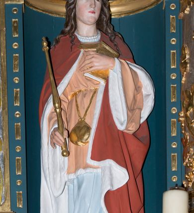 Zdjęcie nr 6: Ołtarz w kaplicy Matki Boskiej Szaflarskiej stanowi przykład przyściennej, architektonicznej, drewnianej nastawy trójosiowej ze zwieńczeniem. Stipes ołtarzowy z drewnianą mensą z kamiennym portatylem uzyskał kształt leżącego prostopadłościanu. Jego przód flankują hermy o trzonach dekorowanych cekinami. W polu zastosowano prostokątną płycinę ujętą kimationem. Na mensie ustawiono prostopadłościenne tabernakulum z wyodrębnionym cokołem i gzymsem koronującym wyłamanym na osi, podtrzymywanym przez dwa pilastry. Krawędzie tabernakulum zdobi imitacja boniowania. Drzwiczki ozdobiono stojącą, prostokątną płyciną, zwieńczoną trójkątnym przyczółkiem. W polu płyciny umieszczono stojący na obłokach płaskorzeźbiony i złocony kielich z hostią otoczoną promieniami. Jednokondygnacyjna nastawa wspiera się na prostokątnej predelli, przechodzącej pod osiami bocznymi w wolutowe konsole. Osie retabulum wydzielone zostały za pomocą skrajnych pilastrów oraz pary kolumn flankujących oś środkową. Podpory dźwigają pełne belkowanie wyłamane na ich osi, przerwane w partii pola środkowego oraz na osiach skrajnych przerwany półokrągły przyczółek. Wewnętrzna para kolumn dźwiga dodatkowo parę konsol podtrzymujących pełne belkowanie wyłamane na ich osi. Zwieńczenie uzyskało formę kwadratu zamkniętego szczytem z krzyżem, ujętego parą kolumienek na cokołach podtrzymujących skrajne woluty. Po zewnętrznych bokach zwieńczenia usytuowano postacie adorujących aniołów. W polu środkowym kondygnacji znalazła się nisza w formie stojącego prostokąta zamkniętego archiwoltą opadającą na belkowanie z konchą wydzieloną przez poziomy gzyms wsparty na dwóch pilastrach. W podniebiu konchy widoczna jest rzeźbiona i srebrzona gołębica Ducha Świętego. W niszy ustawiono figurę Matki Boskiej z Dzieciątkiem stojącą na wysokim czworobocznym postumencie. W osiach bocznych znalazły się nisze zamknięte konchą, u dołu podtrzymywane wspornikiem, z figurami św. Elżbiety Węgierskiej i św. Kazimierza Królewicza. W polu zwieńczenia umieszczono obraz w formie owalu ujęty ramą z przedstawieniem św. Maurycego. Ołtarz w całości pokryty został bogatą i zróżnicowaną dekoracją ornamentalną. Liśćmi akantu ozdobiono cokoły kolumn i wolut podwieszonych pod boczne osie. Kolumny w jednej czwartej wysokości obwiedzione zostały profilowaną listwą wypełnioną rautami. Ich dolne części ozdobiono uskrzydlonymi główkami aniołów z podwieszonymi festonami i girlandami. Z kolei w górnych partiach wykorzystano spiralne wici winnego grona. Dekoracyjnie artykułowano także pilastry, które w jednej czwartej przedzielono profilowanym gzymsem. Ich dolne części szczelnie wypełniono ornamentem okuciowym z rautem w środku, z kolei górne pokryto układającą się swobodnie i symetrycznie wstęgą z kaboszonami. Fryz belkowania wypełniony został wicią roślinną. Pola pomiędzy niszą a belkowaniem ozdobiono uskrzydlonymi główkami aniołów i podwieszonymi pod nimi girlandami. Ponadto uskrzydlone główki aniołów zdobią imposty podstawy zwieńczenia oraz klucz archiwolty ponad niszą główną. Kolumieńki zwieńczenia ozdobione zostały układającą się spiralnie wstęgą. Na dekoracje ornamentalną nastawy składają się również różne zdobienia profilów belkowania i zwieńczenia w postaci kostkowania, wolich oczu oraz pasów utworzonych z liści akantu.
