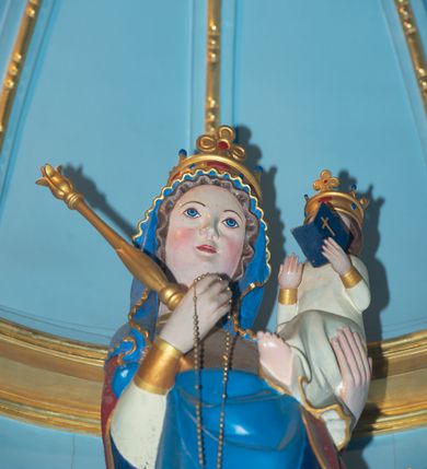 Zdjęcie nr 22: Ołtarz w kaplicy Matki Boskiej Szaflarskiej stanowi przykład przyściennej, architektonicznej, drewnianej nastawy trójosiowej ze zwieńczeniem. Stipes ołtarzowy z drewnianą mensą z kamiennym portatylem uzyskał kształt leżącego prostopadłościanu. Jego przód flankują hermy o trzonach dekorowanych cekinami. W polu zastosowano prostokątną płycinę ujętą kimationem. Na mensie ustawiono prostopadłościenne tabernakulum z wyodrębnionym cokołem i gzymsem koronującym wyłamanym na osi, podtrzymywanym przez dwa pilastry. Krawędzie tabernakulum zdobi imitacja boniowania. Drzwiczki ozdobiono stojącą, prostokątną płyciną, zwieńczoną trójkątnym przyczółkiem. W polu płyciny umieszczono stojący na obłokach płaskorzeźbiony i złocony kielich z hostią otoczoną promieniami. Jednokondygnacyjna nastawa wspiera się na prostokątnej predelli, przechodzącej pod osiami bocznymi w wolutowe konsole. Osie retabulum wydzielone zostały za pomocą skrajnych pilastrów oraz pary kolumn flankujących oś środkową. Podpory dźwigają pełne belkowanie wyłamane na ich osi, przerwane w partii pola środkowego oraz na osiach skrajnych przerwany półokrągły przyczółek. Wewnętrzna para kolumn dźwiga dodatkowo parę konsol podtrzymujących pełne belkowanie wyłamane na ich osi. Zwieńczenie uzyskało formę kwadratu zamkniętego szczytem z krzyżem, ujętego parą kolumienek na cokołach podtrzymujących skrajne woluty. Po zewnętrznych bokach zwieńczenia usytuowano postacie adorujących aniołów. W polu środkowym kondygnacji znalazła się nisza w formie stojącego prostokąta zamkniętego archiwoltą opadającą na belkowanie z konchą wydzieloną przez poziomy gzyms wsparty na dwóch pilastrach. W podniebiu konchy widoczna jest rzeźbiona i srebrzona gołębica Ducha Świętego. W niszy ustawiono figurę Matki Boskiej z Dzieciątkiem stojącą na wysokim czworobocznym postumencie. W osiach bocznych znalazły się nisze zamknięte konchą, u dołu podtrzymywane wspornikiem, z figurami św. Elżbiety Węgierskiej i św. Kazimierza Królewicza. W polu zwieńczenia umieszczono obraz w formie owalu ujęty ramą z przedstawieniem św. Maurycego. Ołtarz w całości pokryty został bogatą i zróżnicowaną dekoracją ornamentalną. Liśćmi akantu ozdobiono cokoły kolumn i wolut podwieszonych pod boczne osie. Kolumny w jednej czwartej wysokości obwiedzione zostały profilowaną listwą wypełnioną rautami. Ich dolne części ozdobiono uskrzydlonymi główkami aniołów z podwieszonymi festonami i girlandami. Z kolei w górnych partiach wykorzystano spiralne wici winnego grona. Dekoracyjnie artykułowano także pilastry, które w jednej czwartej przedzielono profilowanym gzymsem. Ich dolne części szczelnie wypełniono ornamentem okuciowym z rautem w środku, z kolei górne pokryto układającą się swobodnie i symetrycznie wstęgą z kaboszonami. Fryz belkowania wypełniony został wicią roślinną. Pola pomiędzy niszą a belkowaniem ozdobiono uskrzydlonymi główkami aniołów i podwieszonymi pod nimi girlandami. Ponadto uskrzydlone główki aniołów zdobią imposty podstawy zwieńczenia oraz klucz archiwolty ponad niszą główną. Kolumieńki zwieńczenia ozdobione zostały układającą się spiralnie wstęgą. Na dekoracje ornamentalną nastawy składają się również różne zdobienia profilów belkowania i zwieńczenia w postaci kostkowania, wolich oczu oraz pasów utworzonych z liści akantu.
