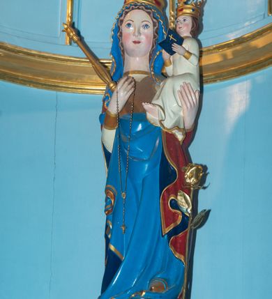 Zdjęcie nr 18: Ołtarz w kaplicy Matki Boskiej Szaflarskiej stanowi przykład przyściennej, architektonicznej, drewnianej nastawy trójosiowej ze zwieńczeniem. Stipes ołtarzowy z drewnianą mensą z kamiennym portatylem uzyskał kształt leżącego prostopadłościanu. Jego przód flankują hermy o trzonach dekorowanych cekinami. W polu zastosowano prostokątną płycinę ujętą kimationem. Na mensie ustawiono prostopadłościenne tabernakulum z wyodrębnionym cokołem i gzymsem koronującym wyłamanym na osi, podtrzymywanym przez dwa pilastry. Krawędzie tabernakulum zdobi imitacja boniowania. Drzwiczki ozdobiono stojącą, prostokątną płyciną, zwieńczoną trójkątnym przyczółkiem. W polu płyciny umieszczono stojący na obłokach płaskorzeźbiony i złocony kielich z hostią otoczoną promieniami. Jednokondygnacyjna nastawa wspiera się na prostokątnej predelli, przechodzącej pod osiami bocznymi w wolutowe konsole. Osie retabulum wydzielone zostały za pomocą skrajnych pilastrów oraz pary kolumn flankujących oś środkową. Podpory dźwigają pełne belkowanie wyłamane na ich osi, przerwane w partii pola środkowego oraz na osiach skrajnych przerwany półokrągły przyczółek. Wewnętrzna para kolumn dźwiga dodatkowo parę konsol podtrzymujących pełne belkowanie wyłamane na ich osi. Zwieńczenie uzyskało formę kwadratu zamkniętego szczytem z krzyżem, ujętego parą kolumienek na cokołach podtrzymujących skrajne woluty. Po zewnętrznych bokach zwieńczenia usytuowano postacie adorujących aniołów. W polu środkowym kondygnacji znalazła się nisza w formie stojącego prostokąta zamkniętego archiwoltą opadającą na belkowanie z konchą wydzieloną przez poziomy gzyms wsparty na dwóch pilastrach. W podniebiu konchy widoczna jest rzeźbiona i srebrzona gołębica Ducha Świętego. W niszy ustawiono figurę Matki Boskiej z Dzieciątkiem stojącą na wysokim czworobocznym postumencie. W osiach bocznych znalazły się nisze zamknięte konchą, u dołu podtrzymywane wspornikiem, z figurami św. Elżbiety Węgierskiej i św. Kazimierza Królewicza. W polu zwieńczenia umieszczono obraz w formie owalu ujęty ramą z przedstawieniem św. Maurycego. Ołtarz w całości pokryty został bogatą i zróżnicowaną dekoracją ornamentalną. Liśćmi akantu ozdobiono cokoły kolumn i wolut podwieszonych pod boczne osie. Kolumny w jednej czwartej wysokości obwiedzione zostały profilowaną listwą wypełnioną rautami. Ich dolne części ozdobiono uskrzydlonymi główkami aniołów z podwieszonymi festonami i girlandami. Z kolei w górnych partiach wykorzystano spiralne wici winnego grona. Dekoracyjnie artykułowano także pilastry, które w jednej czwartej przedzielono profilowanym gzymsem. Ich dolne części szczelnie wypełniono ornamentem okuciowym z rautem w środku, z kolei górne pokryto układającą się swobodnie i symetrycznie wstęgą z kaboszonami. Fryz belkowania wypełniony został wicią roślinną. Pola pomiędzy niszą a belkowaniem ozdobiono uskrzydlonymi główkami aniołów i podwieszonymi pod nimi girlandami. Ponadto uskrzydlone główki aniołów zdobią imposty podstawy zwieńczenia oraz klucz archiwolty ponad niszą główną. Kolumieńki zwieńczenia ozdobione zostały układającą się spiralnie wstęgą. Na dekoracje ornamentalną nastawy składają się również różne zdobienia profilów belkowania i zwieńczenia w postaci kostkowania, wolich oczu oraz pasów utworzonych z liści akantu.
