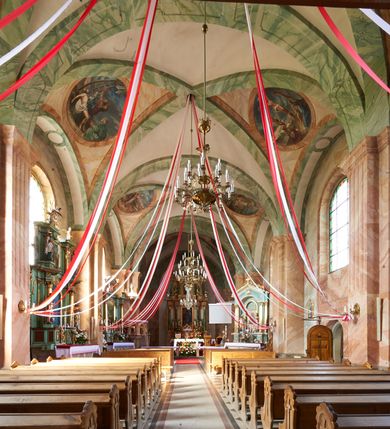 Zdjęcie nr 10: Kościół murowany, tynkowany, orientowany, jednonawowy, na kamiennym podmurowaniu. Prezbiterium jednoprzęsłowe, na planie prostokąta, zamknięte prostą ścianą, od północy prostokątna zakrystia. Nawa główna szersza od prezbiterium, trójprzęsłowa, na rzucie prostokąta, od południa przylega prostokątna kruchta, od zachodu prostokątny przedsionek z wieżą na planie kwadratu o ściętych narożach. Prezbiterium i nawa nakryte sklepieniem krzyżowym wspartym na zdwojonych filarach o kanelowanych trzonach, wydzielających przęsła. Otwór tęczowy w formie półkolistej arkady wspartej na filarach. W zachodniej części wnętrza kościoła parapet chóru muzycznego oparty na dwóch kolumnach. Na osi, pod chórem wejście do przedsionka, na ścianie południowej, w drugim przęśle, wejście do kruchty. Fasada trójosiowa, z wyodrębnionym środkowym wykuszem, osie wydzielone lizenami, zamknięte uproszczonym fryzem arkadkowym. Na osi środkowej dwukondygnacyjny portal wejściowy, w pierwszej kondygnacji flankowany dwiema parami kolumn podtrzymujących trójspadowy daszek, w drugiej czterema słupami podtrzymującymi trójkątny szczyt nakryty daszkiem dwuspadowym, w dolnej partii dekorowany arkadkami, w górnej krzyż. W polu dwuskrzydłowe drzwi wejściowe z nadświetlem w formie stojącego prostokąta zamkniętego łukiem półkolistym, ujęte profilowanym obramieniem. Na osi środkowej, nad portalem okulus, na osiach bocznych, w dolnej partii wąskie okna. Wieża smukła, na zdwojonym cokole, zamknięta wyłamanym trójkątnie gzymsem, nakryta dachem wieżowym zakończonym kulą z krzyżem; na każdej ściance otwory dzwonne w formie wydłużonego stojącego prostokąta zamkniętego łukiem półkolistym. Elewacje gładkie, tynkowane, z podziałami, utworzonymi przez uproszczone pilastry, zakończone fryzem arkadkowym. Na każdej osi duże okno w formie stojącego prostokąta zamkniętego łukiem półkolistym. Nad wejściem do kruchty południowej wnęka w kształcie stojącego prostokąta zamkniętego łukiem półkolistym nadwieszonym, z obrazem św. Jakuba. Nawa główna, prezbiterium i kruchta boczna nakryte dachami dwuspadowymi. W dwóch trzecich długości dachu ośmioboczna wieżyczka na sygnaturkę nakryta dachem wieżowym.


