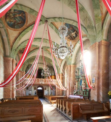 Zdjęcie nr 14: Kościół murowany, tynkowany, orientowany, jednonawowy, na kamiennym podmurowaniu. Prezbiterium jednoprzęsłowe, na planie prostokąta, zamknięte prostą ścianą, od północy prostokątna zakrystia. Nawa główna szersza od prezbiterium, trójprzęsłowa, na rzucie prostokąta, od południa przylega prostokątna kruchta, od zachodu prostokątny przedsionek z wieżą na planie kwadratu o ściętych narożach. Prezbiterium i nawa nakryte sklepieniem krzyżowym wspartym na zdwojonych filarach o kanelowanych trzonach, wydzielających przęsła. Otwór tęczowy w formie półkolistej arkady wspartej na filarach. W zachodniej części wnętrza kościoła parapet chóru muzycznego oparty na dwóch kolumnach. Na osi, pod chórem wejście do przedsionka, na ścianie południowej, w drugim przęśle, wejście do kruchty. Fasada trójosiowa, z wyodrębnionym środkowym wykuszem, osie wydzielone lizenami, zamknięte uproszczonym fryzem arkadkowym. Na osi środkowej dwukondygnacyjny portal wejściowy, w pierwszej kondygnacji flankowany dwiema parami kolumn podtrzymujących trójspadowy daszek, w drugiej czterema słupami podtrzymującymi trójkątny szczyt nakryty daszkiem dwuspadowym, w dolnej partii dekorowany arkadkami, w górnej krzyż. W polu dwuskrzydłowe drzwi wejściowe z nadświetlem w formie stojącego prostokąta zamkniętego łukiem półkolistym, ujęte profilowanym obramieniem. Na osi środkowej, nad portalem okulus, na osiach bocznych, w dolnej partii wąskie okna. Wieża smukła, na zdwojonym cokole, zamknięta wyłamanym trójkątnie gzymsem, nakryta dachem wieżowym zakończonym kulą z krzyżem; na każdej ściance otwory dzwonne w formie wydłużonego stojącego prostokąta zamkniętego łukiem półkolistym. Elewacje gładkie, tynkowane, z podziałami, utworzonymi przez uproszczone pilastry, zakończone fryzem arkadkowym. Na każdej osi duże okno w formie stojącego prostokąta zamkniętego łukiem półkolistym. Nad wejściem do kruchty południowej wnęka w kształcie stojącego prostokąta zamkniętego łukiem półkolistym nadwieszonym, z obrazem św. Jakuba. Nawa główna, prezbiterium i kruchta boczna nakryte dachami dwuspadowymi. W dwóch trzecich długości dachu ośmioboczna wieżyczka na sygnaturkę nakryta dachem wieżowym.


