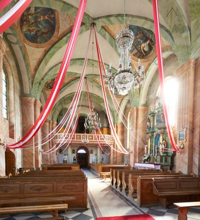 Zdjęcie nr 17: Kościół murowany, tynkowany, orientowany, jednonawowy, na kamiennym podmurowaniu. Prezbiterium jednoprzęsłowe, na planie prostokąta, zamknięte prostą ścianą, od północy prostokątna zakrystia. Nawa główna szersza od prezbiterium, trójprzęsłowa, na rzucie prostokąta, od południa przylega prostokątna kruchta, od zachodu prostokątny przedsionek z wieżą na planie kwadratu o ściętych narożach. Prezbiterium i nawa nakryte sklepieniem krzyżowym wspartym na zdwojonych filarach o kanelowanych trzonach, wydzielających przęsła. Otwór tęczowy w formie półkolistej arkady wspartej na filarach. W zachodniej części wnętrza kościoła parapet chóru muzycznego oparty na dwóch kolumnach. Na osi, pod chórem wejście do przedsionka, na ścianie południowej, w drugim przęśle, wejście do kruchty. Fasada trójosiowa, z wyodrębnionym środkowym wykuszem, osie wydzielone lizenami, zamknięte uproszczonym fryzem arkadkowym. Na osi środkowej dwukondygnacyjny portal wejściowy, w pierwszej kondygnacji flankowany dwiema parami kolumn podtrzymujących trójspadowy daszek, w drugiej czterema słupami podtrzymującymi trójkątny szczyt nakryty daszkiem dwuspadowym, w dolnej partii dekorowany arkadkami, w górnej krzyż. W polu dwuskrzydłowe drzwi wejściowe z nadświetlem w formie stojącego prostokąta zamkniętego łukiem półkolistym, ujęte profilowanym obramieniem. Na osi środkowej, nad portalem okulus, na osiach bocznych, w dolnej partii wąskie okna. Wieża smukła, na zdwojonym cokole, zamknięta wyłamanym trójkątnie gzymsem, nakryta dachem wieżowym zakończonym kulą z krzyżem; na każdej ściance otwory dzwonne w formie wydłużonego stojącego prostokąta zamkniętego łukiem półkolistym. Elewacje gładkie, tynkowane, z podziałami, utworzonymi przez uproszczone pilastry, zakończone fryzem arkadkowym. Na każdej osi duże okno w formie stojącego prostokąta zamkniętego łukiem półkolistym. Nad wejściem do kruchty południowej wnęka w kształcie stojącego prostokąta zamkniętego łukiem półkolistym nadwieszonym, z obrazem św. Jakuba. Nawa główna, prezbiterium i kruchta boczna nakryte dachami dwuspadowymi. W dwóch trzecich długości dachu ośmioboczna wieżyczka na sygnaturkę nakryta dachem wieżowym.


