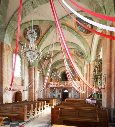 Zdjęcie nr 15: Kościół murowany, tynkowany, orientowany, jednonawowy, na kamiennym podmurowaniu. Prezbiterium jednoprzęsłowe, na planie prostokąta, zamknięte prostą ścianą, od północy prostokątna zakrystia. Nawa główna szersza od prezbiterium, trójprzęsłowa, na rzucie prostokąta, od południa przylega prostokątna kruchta, od zachodu prostokątny przedsionek z wieżą na planie kwadratu o ściętych narożach. Prezbiterium i nawa nakryte sklepieniem krzyżowym wspartym na zdwojonych filarach o kanelowanych trzonach, wydzielających przęsła. Otwór tęczowy w formie półkolistej arkady wspartej na filarach. W zachodniej części wnętrza kościoła parapet chóru muzycznego oparty na dwóch kolumnach. Na osi, pod chórem wejście do przedsionka, na ścianie południowej, w drugim przęśle, wejście do kruchty. Fasada trójosiowa, z wyodrębnionym środkowym wykuszem, osie wydzielone lizenami, zamknięte uproszczonym fryzem arkadkowym. Na osi środkowej dwukondygnacyjny portal wejściowy, w pierwszej kondygnacji flankowany dwiema parami kolumn podtrzymujących trójspadowy daszek, w drugiej czterema słupami podtrzymującymi trójkątny szczyt nakryty daszkiem dwuspadowym, w dolnej partii dekorowany arkadkami, w górnej krzyż. W polu dwuskrzydłowe drzwi wejściowe z nadświetlem w formie stojącego prostokąta zamkniętego łukiem półkolistym, ujęte profilowanym obramieniem. Na osi środkowej, nad portalem okulus, na osiach bocznych, w dolnej partii wąskie okna. Wieża smukła, na zdwojonym cokole, zamknięta wyłamanym trójkątnie gzymsem, nakryta dachem wieżowym zakończonym kulą z krzyżem; na każdej ściance otwory dzwonne w formie wydłużonego stojącego prostokąta zamkniętego łukiem półkolistym. Elewacje gładkie, tynkowane, z podziałami, utworzonymi przez uproszczone pilastry, zakończone fryzem arkadkowym. Na każdej osi duże okno w formie stojącego prostokąta zamkniętego łukiem półkolistym. Nad wejściem do kruchty południowej wnęka w kształcie stojącego prostokąta zamkniętego łukiem półkolistym nadwieszonym, z obrazem św. Jakuba. Nawa główna, prezbiterium i kruchta boczna nakryte dachami dwuspadowymi. W dwóch trzecich długości dachu ośmioboczna wieżyczka na sygnaturkę nakryta dachem wieżowym.


