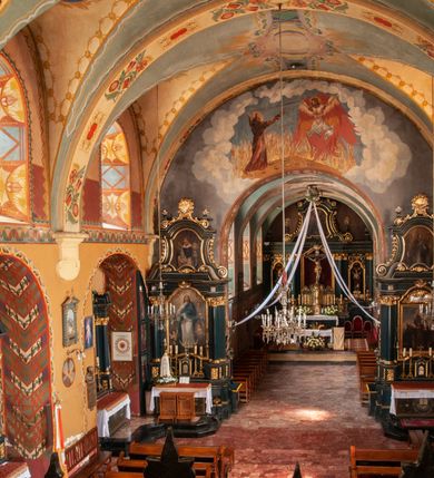 Zdjęcie nr 9: Kościół jest położony na wzgórzu w pobliżu centrum, przy ul. Brata Alojzego Kosiby. Od zachodu przed kościołem znajduje się dziedziniec i dawny cmentarz obwiedzione murem z bramkami i stacjami Męki Pańskiej. Z cmentarza wejście prowadzi do kościoła, a przez furtę na teren przyklasztorny i dalej do ogrodu klasztornego. Kościół wzniesiony jest z cegły, otynkowany. Świątynia jest orientowana, jednonawowa, z węższym prezbiterium, z kaplicą od północy i kruchtą od zachodu. Przy kościele od południa znajdują się zakrystia i zabudowania klasztorne. Prezbiterium na rzucie prostokąta, zamknięte od wschodu prostą ścianą, trójprzęsłowe, przekryte sklepieniem kolebkowym z przecinającymi się lunetami. W każdym przęśle ściany północnej wysoko umieszczone półkoliście zamknięte okna. Otworom okiennym odpowiadają tej samej wielkości nisze umieszczone w ścianie południowej. Wejście do klasztornego korytarza i zakrystii umieszczone jest w przęśle środkowym. Odpowiada mu otwór komunikacyjny po stronie przeciwnej. W przęśle zachodnim zlokalizowano drugie wejście do południowego korytarza klasztornego. Przestrzeń miedzy prezbiterium a korpusem zawężona arkadą tęczową, zamkniętą półkoliście. Korpus jednonawowy, szerszy z wnękami na ołtarze, czteroprzęsłowy, przekryty sklepieniem kolebkowym na gurtach z lunetami. Wnęka w trzecim przęśle od wschodu zamieniona na otwór do kaplicy północnej. Połowę przęsła zachodniego zajmuje empora muzyczna oparta na nisko schodzącym sklepieniu kolebkowym. Przy emporze, w ścianach wzdłużnych nawy, znacznie mniejsze, półkoliście zamknięte wnęki na konfesjonały. W lunetach, po obu stronach półkoliście zamknięte okna. Okna w przęśle zachodnim zastępują tej samej wielkości nisze. Główne wejście do kościoła w osi ściany zachodniej, zamknięte łukiem odcinkowym. W osi nad chórem muzycznym, półkoliście zamknięte okno, większe od pozostałych. Wejście do kościoła objęte prostokątnym portalem z piaskowca. Kaplica północna wzniesiona na planie kwadratu, przekryta sklepieniem współczesnym, zbliżonym w formie do klasztornego, zwieńczona latarnią. Okna, umieszczone w ścianie wschodniej i zachodniej, o tym samym wykroju utworzonym z wąskiego prostokąta przechodzącego górą w formę wachlarza lub wycinka koła. Zewnętrzne elewacje artykułuje podział osiowy i dekoracja lizenowo-ramowa, złożona z wydatnych elementów wertykalnych i horyzontalnych. Jednoosiową fasadę nad kruchtą ozdabia poniżej okna profilowany gzyms. Całość zamknięta wysoką, trójkątną ścianą szczytową, z trzema półkoliście zamkniętymi niszami. W nich polichromowane płaskorzeźby o kształcie stojącego prostokąta zamkniętego łukiem pełnym przedstawiające: stygmatyzację św. Franciszka, św. Piotra z Alkantary, św. Antoniego Padewskiego. Szczyt zwieńczony metalowym krzyżem osadzonym na niskim cokole. Kruchta przy fasadzie  z dwoma wejściami. Wejście zachodnie obejmuje półkoliście zamknięty portal z piaskowca, z dekoracją płycinową na węgarach, z kapitelami i skromnie profilowaną archiwoltą spiętą kluczem. Węższe wejście od północy z prostym, półkoliście zamkniętym portalem z piaskowca. Budowlę zamkniętą profilowanym gzymsem wieńczy trójkątny naczółek, przechodzący po bokach w balustradę z dekoracją płycinową. Na narożnych słupkach balustrady obeliskowe sterczyny. W półkoliście zamkniętej wnęce, umieszczonej pośrodku naczółka, wizerunek Matki Boskiej Nieustającej Pomocy. Wschodnia ściana prezbiterium, w dolnej partii zupełnie płaska, w górnej z triadą prostokątnych wnęk. Część szczytową oddziela od dolnej profilowany gzyms kryty dachówką. W osi trójkątnego szczytu wschodniego prostokątna wnęka z płaskorzeźbioną i polichromowaną sceną przedstawiającą św. Porcjunkulę w towarzystwie Chrystusa oraz św. Franciszka. Bryłę świątyni zamykają wysokie dachy dwuspadowe. Pośrodku dachu prezbiterium wieloboczna wieżyczka na sygnaturkę z ażurową latarnią. Bryłę kaplicy przekrywa dach czterospadowy. Ośmioboczną formę jej latarni zamyka dach wielospadowy zwieńczony metalowym krzyżem.