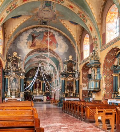 Zdjęcie nr 12: Kościół jest położony na wzgórzu w pobliżu centrum, przy ul. Brata Alojzego Kosiby. Od zachodu przed kościołem znajduje się dziedziniec i dawny cmentarz obwiedzione murem z bramkami i stacjami Męki Pańskiej. Z cmentarza wejście prowadzi do kościoła, a przez furtę na teren przyklasztorny i dalej do ogrodu klasztornego. Kościół wzniesiony jest z cegły, otynkowany. Świątynia jest orientowana, jednonawowa, z węższym prezbiterium, z kaplicą od północy i kruchtą od zachodu. Przy kościele od południa znajdują się zakrystia i zabudowania klasztorne. Prezbiterium na rzucie prostokąta, zamknięte od wschodu prostą ścianą, trójprzęsłowe, przekryte sklepieniem kolebkowym z przecinającymi się lunetami. W każdym przęśle ściany północnej wysoko umieszczone półkoliście zamknięte okna. Otworom okiennym odpowiadają tej samej wielkości nisze umieszczone w ścianie południowej. Wejście do klasztornego korytarza i zakrystii umieszczone jest w przęśle środkowym. Odpowiada mu otwór komunikacyjny po stronie przeciwnej. W przęśle zachodnim zlokalizowano drugie wejście do południowego korytarza klasztornego. Przestrzeń miedzy prezbiterium a korpusem zawężona arkadą tęczową, zamkniętą półkoliście. Korpus jednonawowy, szerszy z wnękami na ołtarze, czteroprzęsłowy, przekryty sklepieniem kolebkowym na gurtach z lunetami. Wnęka w trzecim przęśle od wschodu zamieniona na otwór do kaplicy północnej. Połowę przęsła zachodniego zajmuje empora muzyczna oparta na nisko schodzącym sklepieniu kolebkowym. Przy emporze, w ścianach wzdłużnych nawy, znacznie mniejsze, półkoliście zamknięte wnęki na konfesjonały. W lunetach, po obu stronach półkoliście zamknięte okna. Okna w przęśle zachodnim zastępują tej samej wielkości nisze. Główne wejście do kościoła w osi ściany zachodniej, zamknięte łukiem odcinkowym. W osi nad chórem muzycznym, półkoliście zamknięte okno, większe od pozostałych. Wejście do kościoła objęte prostokątnym portalem z piaskowca. Kaplica północna wzniesiona na planie kwadratu, przekryta sklepieniem współczesnym, zbliżonym w formie do klasztornego, zwieńczona latarnią. Okna, umieszczone w ścianie wschodniej i zachodniej, o tym samym wykroju utworzonym z wąskiego prostokąta przechodzącego górą w formę wachlarza lub wycinka koła. Zewnętrzne elewacje artykułuje podział osiowy i dekoracja lizenowo-ramowa, złożona z wydatnych elementów wertykalnych i horyzontalnych. Jednoosiową fasadę nad kruchtą ozdabia poniżej okna profilowany gzyms. Całość zamknięta wysoką, trójkątną ścianą szczytową, z trzema półkoliście zamkniętymi niszami. W nich polichromowane płaskorzeźby o kształcie stojącego prostokąta zamkniętego łukiem pełnym przedstawiające: stygmatyzację św. Franciszka, św. Piotra z Alkantary, św. Antoniego Padewskiego. Szczyt zwieńczony metalowym krzyżem osadzonym na niskim cokole. Kruchta przy fasadzie  z dwoma wejściami. Wejście zachodnie obejmuje półkoliście zamknięty portal z piaskowca, z dekoracją płycinową na węgarach, z kapitelami i skromnie profilowaną archiwoltą spiętą kluczem. Węższe wejście od północy z prostym, półkoliście zamkniętym portalem z piaskowca. Budowlę zamkniętą profilowanym gzymsem wieńczy trójkątny naczółek, przechodzący po bokach w balustradę z dekoracją płycinową. Na narożnych słupkach balustrady obeliskowe sterczyny. W półkoliście zamkniętej wnęce, umieszczonej pośrodku naczółka, wizerunek Matki Boskiej Nieustającej Pomocy. Wschodnia ściana prezbiterium, w dolnej partii zupełnie płaska, w górnej z triadą prostokątnych wnęk. Część szczytową oddziela od dolnej profilowany gzyms kryty dachówką. W osi trójkątnego szczytu wschodniego prostokątna wnęka z płaskorzeźbioną i polichromowaną sceną przedstawiającą św. Porcjunkulę w towarzystwie Chrystusa oraz św. Franciszka. Bryłę świątyni zamykają wysokie dachy dwuspadowe. Pośrodku dachu prezbiterium wieloboczna wieżyczka na sygnaturkę z ażurową latarnią. Bryłę kaplicy przekrywa dach czterospadowy. Ośmioboczną formę jej latarni zamyka dach wielospadowy zwieńczony metalowym krzyżem.