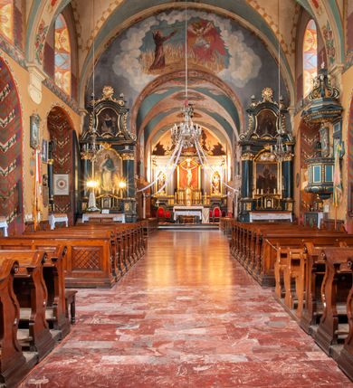 Zdjęcie nr 15: Kościół jest położony na wzgórzu w pobliżu centrum, przy ul. Brata Alojzego Kosiby. Od zachodu przed kościołem znajduje się dziedziniec i dawny cmentarz obwiedzione murem z bramkami i stacjami Męki Pańskiej. Z cmentarza wejście prowadzi do kościoła, a przez furtę na teren przyklasztorny i dalej do ogrodu klasztornego. Kościół wzniesiony jest z cegły, otynkowany. Świątynia jest orientowana, jednonawowa, z węższym prezbiterium, z kaplicą od północy i kruchtą od zachodu. Przy kościele od południa znajdują się zakrystia i zabudowania klasztorne. Prezbiterium na rzucie prostokąta, zamknięte od wschodu prostą ścianą, trójprzęsłowe, przekryte sklepieniem kolebkowym z przecinającymi się lunetami. W każdym przęśle ściany północnej wysoko umieszczone półkoliście zamknięte okna. Otworom okiennym odpowiadają tej samej wielkości nisze umieszczone w ścianie południowej. Wejście do klasztornego korytarza i zakrystii umieszczone jest w przęśle środkowym. Odpowiada mu otwór komunikacyjny po stronie przeciwnej. W przęśle zachodnim zlokalizowano drugie wejście do południowego korytarza klasztornego. Przestrzeń miedzy prezbiterium a korpusem zawężona arkadą tęczową, zamkniętą półkoliście. Korpus jednonawowy, szerszy z wnękami na ołtarze, czteroprzęsłowy, przekryty sklepieniem kolebkowym na gurtach z lunetami. Wnęka w trzecim przęśle od wschodu zamieniona na otwór do kaplicy północnej. Połowę przęsła zachodniego zajmuje empora muzyczna oparta na nisko schodzącym sklepieniu kolebkowym. Przy emporze, w ścianach wzdłużnych nawy, znacznie mniejsze, półkoliście zamknięte wnęki na konfesjonały. W lunetach, po obu stronach półkoliście zamknięte okna. Okna w przęśle zachodnim zastępują tej samej wielkości nisze. Główne wejście do kościoła w osi ściany zachodniej, zamknięte łukiem odcinkowym. W osi nad chórem muzycznym, półkoliście zamknięte okno, większe od pozostałych. Wejście do kościoła objęte prostokątnym portalem z piaskowca. Kaplica północna wzniesiona na planie kwadratu, przekryta sklepieniem współczesnym, zbliżonym w formie do klasztornego, zwieńczona latarnią. Okna, umieszczone w ścianie wschodniej i zachodniej, o tym samym wykroju utworzonym z wąskiego prostokąta przechodzącego górą w formę wachlarza lub wycinka koła. Zewnętrzne elewacje artykułuje podział osiowy i dekoracja lizenowo-ramowa, złożona z wydatnych elementów wertykalnych i horyzontalnych. Jednoosiową fasadę nad kruchtą ozdabia poniżej okna profilowany gzyms. Całość zamknięta wysoką, trójkątną ścianą szczytową, z trzema półkoliście zamkniętymi niszami. W nich polichromowane płaskorzeźby o kształcie stojącego prostokąta zamkniętego łukiem pełnym przedstawiające: stygmatyzację św. Franciszka, św. Piotra z Alkantary, św. Antoniego Padewskiego. Szczyt zwieńczony metalowym krzyżem osadzonym na niskim cokole. Kruchta przy fasadzie  z dwoma wejściami. Wejście zachodnie obejmuje półkoliście zamknięty portal z piaskowca, z dekoracją płycinową na węgarach, z kapitelami i skromnie profilowaną archiwoltą spiętą kluczem. Węższe wejście od północy z prostym, półkoliście zamkniętym portalem z piaskowca. Budowlę zamkniętą profilowanym gzymsem wieńczy trójkątny naczółek, przechodzący po bokach w balustradę z dekoracją płycinową. Na narożnych słupkach balustrady obeliskowe sterczyny. W półkoliście zamkniętej wnęce, umieszczonej pośrodku naczółka, wizerunek Matki Boskiej Nieustającej Pomocy. Wschodnia ściana prezbiterium, w dolnej partii zupełnie płaska, w górnej z triadą prostokątnych wnęk. Część szczytową oddziela od dolnej profilowany gzyms kryty dachówką. W osi trójkątnego szczytu wschodniego prostokątna wnęka z płaskorzeźbioną i polichromowaną sceną przedstawiającą św. Porcjunkulę w towarzystwie Chrystusa oraz św. Franciszka. Bryłę świątyni zamykają wysokie dachy dwuspadowe. Pośrodku dachu prezbiterium wieloboczna wieżyczka na sygnaturkę z ażurową latarnią. Bryłę kaplicy przekrywa dach czterospadowy. Ośmioboczną formę jej latarni zamyka dach wielospadowy zwieńczony metalowym krzyżem.