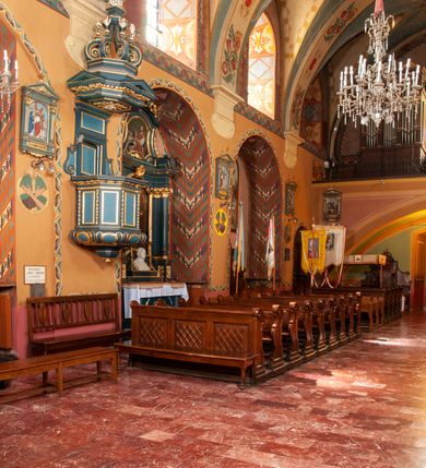 Zdjęcie nr 22: Kościół jest położony na wzgórzu w pobliżu centrum, przy ul. Brata Alojzego Kosiby. Od zachodu przed kościołem znajduje się dziedziniec i dawny cmentarz obwiedzione murem z bramkami i stacjami Męki Pańskiej. Z cmentarza wejście prowadzi do kościoła, a przez furtę na teren przyklasztorny i dalej do ogrodu klasztornego. Kościół wzniesiony jest z cegły, otynkowany. Świątynia jest orientowana, jednonawowa, z węższym prezbiterium, z kaplicą od północy i kruchtą od zachodu. Przy kościele od południa znajdują się zakrystia i zabudowania klasztorne. Prezbiterium na rzucie prostokąta, zamknięte od wschodu prostą ścianą, trójprzęsłowe, przekryte sklepieniem kolebkowym z przecinającymi się lunetami. W każdym przęśle ściany północnej wysoko umieszczone półkoliście zamknięte okna. Otworom okiennym odpowiadają tej samej wielkości nisze umieszczone w ścianie południowej. Wejście do klasztornego korytarza i zakrystii umieszczone jest w przęśle środkowym. Odpowiada mu otwór komunikacyjny po stronie przeciwnej. W przęśle zachodnim zlokalizowano drugie wejście do południowego korytarza klasztornego. Przestrzeń miedzy prezbiterium a korpusem zawężona arkadą tęczową, zamkniętą półkoliście. Korpus jednonawowy, szerszy z wnękami na ołtarze, czteroprzęsłowy, przekryty sklepieniem kolebkowym na gurtach z lunetami. Wnęka w trzecim przęśle od wschodu zamieniona na otwór do kaplicy północnej. Połowę przęsła zachodniego zajmuje empora muzyczna oparta na nisko schodzącym sklepieniu kolebkowym. Przy emporze, w ścianach wzdłużnych nawy, znacznie mniejsze, półkoliście zamknięte wnęki na konfesjonały. W lunetach, po obu stronach półkoliście zamknięte okna. Okna w przęśle zachodnim zastępują tej samej wielkości nisze. Główne wejście do kościoła w osi ściany zachodniej, zamknięte łukiem odcinkowym. W osi nad chórem muzycznym, półkoliście zamknięte okno, większe od pozostałych. Wejście do kościoła objęte prostokątnym portalem z piaskowca. Kaplica północna wzniesiona na planie kwadratu, przekryta sklepieniem współczesnym, zbliżonym w formie do klasztornego, zwieńczona latarnią. Okna, umieszczone w ścianie wschodniej i zachodniej, o tym samym wykroju utworzonym z wąskiego prostokąta przechodzącego górą w formę wachlarza lub wycinka koła. Zewnętrzne elewacje artykułuje podział osiowy i dekoracja lizenowo-ramowa, złożona z wydatnych elementów wertykalnych i horyzontalnych. Jednoosiową fasadę nad kruchtą ozdabia poniżej okna profilowany gzyms. Całość zamknięta wysoką, trójkątną ścianą szczytową, z trzema półkoliście zamkniętymi niszami. W nich polichromowane płaskorzeźby o kształcie stojącego prostokąta zamkniętego łukiem pełnym przedstawiające: stygmatyzację św. Franciszka, św. Piotra z Alkantary, św. Antoniego Padewskiego. Szczyt zwieńczony metalowym krzyżem osadzonym na niskim cokole. Kruchta przy fasadzie  z dwoma wejściami. Wejście zachodnie obejmuje półkoliście zamknięty portal z piaskowca, z dekoracją płycinową na węgarach, z kapitelami i skromnie profilowaną archiwoltą spiętą kluczem. Węższe wejście od północy z prostym, półkoliście zamkniętym portalem z piaskowca. Budowlę zamkniętą profilowanym gzymsem wieńczy trójkątny naczółek, przechodzący po bokach w balustradę z dekoracją płycinową. Na narożnych słupkach balustrady obeliskowe sterczyny. W półkoliście zamkniętej wnęce, umieszczonej pośrodku naczółka, wizerunek Matki Boskiej Nieustającej Pomocy. Wschodnia ściana prezbiterium, w dolnej partii zupełnie płaska, w górnej z triadą prostokątnych wnęk. Część szczytową oddziela od dolnej profilowany gzyms kryty dachówką. W osi trójkątnego szczytu wschodniego prostokątna wnęka z płaskorzeźbioną i polichromowaną sceną przedstawiającą św. Porcjunkulę w towarzystwie Chrystusa oraz św. Franciszka. Bryłę świątyni zamykają wysokie dachy dwuspadowe. Pośrodku dachu prezbiterium wieloboczna wieżyczka na sygnaturkę z ażurową latarnią. Bryłę kaplicy przekrywa dach czterospadowy. Ośmioboczną formę jej latarni zamyka dach wielospadowy zwieńczony metalowym krzyżem.