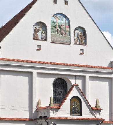 Zdjęcie nr 2: Kościół jest położony na wzgórzu w pobliżu centrum, przy ul. Brata Alojzego Kosiby. Od zachodu przed kościołem znajduje się dziedziniec i dawny cmentarz obwiedzione murem z bramkami i stacjami Męki Pańskiej. Z cmentarza wejście prowadzi do kościoła, a przez furtę na teren przyklasztorny i dalej do ogrodu klasztornego. Kościół wzniesiony jest z cegły, otynkowany. Świątynia jest orientowana, jednonawowa, z węższym prezbiterium, z kaplicą od północy i kruchtą od zachodu. Przy kościele od południa znajdują się zakrystia i zabudowania klasztorne. Prezbiterium na rzucie prostokąta, zamknięte od wschodu prostą ścianą, trójprzęsłowe, przekryte sklepieniem kolebkowym z przecinającymi się lunetami. W każdym przęśle ściany północnej wysoko umieszczone półkoliście zamknięte okna. Otworom okiennym odpowiadają tej samej wielkości nisze umieszczone w ścianie południowej. Wejście do klasztornego korytarza i zakrystii umieszczone jest w przęśle środkowym. Odpowiada mu otwór komunikacyjny po stronie przeciwnej. W przęśle zachodnim zlokalizowano drugie wejście do południowego korytarza klasztornego. Przestrzeń miedzy prezbiterium a korpusem zawężona arkadą tęczową, zamkniętą półkoliście. Korpus jednonawowy, szerszy z wnękami na ołtarze, czteroprzęsłowy, przekryty sklepieniem kolebkowym na gurtach z lunetami. Wnęka w trzecim przęśle od wschodu zamieniona na otwór do kaplicy północnej. Połowę przęsła zachodniego zajmuje empora muzyczna oparta na nisko schodzącym sklepieniu kolebkowym. Przy emporze, w ścianach wzdłużnych nawy, znacznie mniejsze, półkoliście zamknięte wnęki na konfesjonały. W lunetach, po obu stronach półkoliście zamknięte okna. Okna w przęśle zachodnim zastępują tej samej wielkości nisze. Główne wejście do kościoła w osi ściany zachodniej, zamknięte łukiem odcinkowym. W osi nad chórem muzycznym, półkoliście zamknięte okno, większe od pozostałych. Wejście do kościoła objęte prostokątnym portalem z piaskowca. Kaplica północna wzniesiona na planie kwadratu, przekryta sklepieniem współczesnym, zbliżonym w formie do klasztornego, zwieńczona latarnią. Okna, umieszczone w ścianie wschodniej i zachodniej, o tym samym wykroju utworzonym z wąskiego prostokąta przechodzącego górą w formę wachlarza lub wycinka koła. Zewnętrzne elewacje artykułuje podział osiowy i dekoracja lizenowo-ramowa, złożona z wydatnych elementów wertykalnych i horyzontalnych. Jednoosiową fasadę nad kruchtą ozdabia poniżej okna profilowany gzyms. Całość zamknięta wysoką, trójkątną ścianą szczytową, z trzema półkoliście zamkniętymi niszami. W nich polichromowane płaskorzeźby o kształcie stojącego prostokąta zamkniętego łukiem pełnym przedstawiające: stygmatyzację św. Franciszka, św. Piotra z Alkantary, św. Antoniego Padewskiego. Szczyt zwieńczony metalowym krzyżem osadzonym na niskim cokole. Kruchta przy fasadzie  z dwoma wejściami. Wejście zachodnie obejmuje półkoliście zamknięty portal z piaskowca, z dekoracją płycinową na węgarach, z kapitelami i skromnie profilowaną archiwoltą spiętą kluczem. Węższe wejście od północy z prostym, półkoliście zamkniętym portalem z piaskowca. Budowlę zamkniętą profilowanym gzymsem wieńczy trójkątny naczółek, przechodzący po bokach w balustradę z dekoracją płycinową. Na narożnych słupkach balustrady obeliskowe sterczyny. W półkoliście zamkniętej wnęce, umieszczonej pośrodku naczółka, wizerunek Matki Boskiej Nieustającej Pomocy. Wschodnia ściana prezbiterium, w dolnej partii zupełnie płaska, w górnej z triadą prostokątnych wnęk. Część szczytową oddziela od dolnej profilowany gzyms kryty dachówką. W osi trójkątnego szczytu wschodniego prostokątna wnęka z płaskorzeźbioną i polichromowaną sceną przedstawiającą św. Porcjunkulę w towarzystwie Chrystusa oraz św. Franciszka. Bryłę świątyni zamykają wysokie dachy dwuspadowe. Pośrodku dachu prezbiterium wieloboczna wieżyczka na sygnaturkę z ażurową latarnią. Bryłę kaplicy przekrywa dach czterospadowy. Ośmioboczną formę jej latarni zamyka dach wielospadowy zwieńczony metalowym krzyżem.