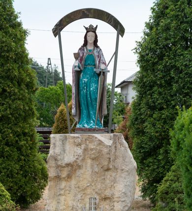 Zdjęcie nr 11: Kościół z drewna modrzewiowego o konstrukcji zrębowej, na betonowej podmurówce, otoczony drewnianym ogrodzeniem. Bryła składa się z korpusu nawowego na planie prostokąta oraz z wydłużonego, prostokątnego prezbiterium z zakrystią na przedłużeniu, węższego od nawy, zakończonego ścianą prostą, skierowanego na południe. Od strony północnej dobudowana jest prostokątna kruchta, od zachodu dwa przedsionki na dwóch skrajnych bokach –  przy nawie i prezbiterium. 
Trójprzęsłowe prezbiterium nakryte jest  sklepieniem pozornym zwierciadlanym, które przedłuża się nad nawę środkową. Ściany prezbiterium artykułowane pilastrami dzielą je na trzy przęsła. Kapitele pilastrów dźwigają nasadniki, które podtrzymują gzymsik. Przedłużeniem kapiteli w strefie stropu są płaskie belki biegnące przez całą jego szerokość, wyznaczając tym samym pola, w których umieszczono polichromię. Po obu stronach ołtarza drzwi w kształcie stojącego prostokąta. Prezbiterium od korpusu nawowego oddzielone silnie wystającą belką sklepienia oraz belką tęczową z grupą Ukrzyżowania. 
Korpus o trzech nawach o układzie halowym, z których środkowa jest dwa razy szersza od bocznych, trójprzęsłowa, z nawami oddzielonymi kanelowanymi filarami z nasadnikami podtrzymującymi gzyms. Nawy boczne nakryte kolebką. Na linii filarów pilastry na ścianach, łączą je poprzeczne belki sklepienia. W ostatnim przęśle chór muzyczny wsparty na dwóch filarach, z pełnym parapetem występującym w części środkowej trójbocznie do przodu. Jego krawędź dolna dekorowana jest lambrekinem. Ściany kościoła pokryte polichormią, pomalowane na jasnożółto, z jasnozielonymi podporami i brązowymi liniami podziału stropu. Te elementy wyznaczają ramy wypełnione polami z dekoracją ornamentalną w kształcie prostokątów i scenami figuralnymi zamkniętymi w kołach. 
Otwory okienne w drugim i trzecim przęśle nawy, od wschodu i zachodu, prostokątne. Także w prezbiterium po jednym prostokątnym oknie z każdej strony. Od strony wejścia dwa niewielkie okna prostokątne ponad kruchtą. Na ścianie zamknięcia zakrystii cztery prostokątne, symetrycznie rozłożone okna. 
 Fasada poprzedzona przedsionkiem w kształcie prostopadłościanu nakrytego dachem dwuspadowym, z przyczółkiem. Otwór drzwiowy w formie stojącego prostokąta, a w szczycie przyczółka trójkątne, wielodzielne okienko. Fasada w kształcie leżącego prostokąta z trójkątnym szczytem, części oddzielone daszkiem pulpitowym. Po dwóch stronach przedsionka prostokątne okna, w szczycie fasady  nakryty daszkiem krucyfiks. 
Elewacje zewnętrzne na podmurówce, artykułowane jedynie pionowymi, wystającymi przed lico belkami, przeprute oknami. Nad nawą i prezbiterium dachy dwuspadowe, nad prezbiterium niższy niż nad nawą, kryty blachą. Nad nawą wieżyczka na sygnaturkę zwieńczona cebulastym hełmem i krzyżem na szczycie. Na końcach dachu przy prezbiterium i nawie metalowe krzyże. 
