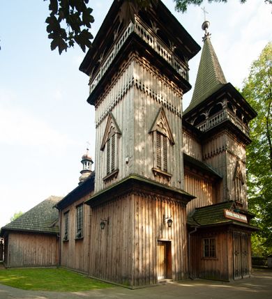 Zdjęcie nr 2: Kościół drewniany, orientowany, z dwuczęściowym korpusem: od wschodu jednonawowym, od zachodu trójnawowym; z prezbiterium zamkniętym trójbocznie, przy którym zakrystia od północy, z przybudówką od południa i dwiema wieżami od zachodu. Od wschodu chór muzyczny wbudowany pomiędzy wieże. Kościół wzniesiono w konstrukcji zrębowej, wieże w słupowo-ramowej, ściany oszalowane pionowym listwowaniem. 
Ściany prezbiterium i wschodniej części korpusu podzielone pseudokolumnami, zachodnia część podzielona kolumnami dźwigającymi architraw. Prezbiterium oddziela półokrągły łuk tęczowy; wschodnią i zachodnią część nawy łuk spłaszczony. Wschodnią część nawy oraz nawy boczne części zachodniej przekrywa płaski strop, zachodnią pozorne sklepienie zwierciadlane. Ściany oraz stropy pokryte polichromią figuralną, ornamentalną oraz roślinną: w prezbiterium namalowano wizerunek Ukrzyżowanego Chrystusa, przed łukiem tęczowym Matkę Boską w otoczeniu tajemnic różańcowych. Strop nawy imituje gwiaździste niebo. Posadzka kamienna. Wejście główne od zachodu, dwoje drzwi spod wież, kolejne od południa, przez przedsionek (babiniec), do zakrystii prowadzi portal zamknięty łukiem nadwieszonym. Cztery okna w prezbiterium o wykroju prostokątnym zamkniętym łukiem nadwieszonym, cztery we wschodniej części nawy o takim samym kształcie, cztery w zachodniej części zamknięte podwójnym łukiem kotarowym, dwa w zakrystii, południowej przybudówce, po dwa wysokie, wąskie okna w wieżach. Fasada dwuwieżowa, trójosiowa, trójkondygnacyjna. Przed wejściem kruchta zwieńczona dachem dwuspadowym, do której prowadzą dwuskrzydłowe drzwi w kształcie prostokątów, ściany boczne przeprute oknami. Powyżej dwie gładkie kondygnacje przedzielone dachem pulpitowym. Wieże trójkondygnacyjne, w dolnej kondygnacji drzwi, w wyższej okna w kształcie stojących prostokątów zamkniętych łukiem ostrym z wyciętym od dołu fragmentem pięcioliścia, powyżej ażurowa koronka. Ostatnią kondygnację tworzy izbica z nadwieszonym gankiem zamkniętym łukami spłaszczonymi. Od zewnątrz wyraźny podział na bryły, ściany gładkie. Każdą część przykrywa gontowy dach dwuspadowy, wspólny dla prezbiterium i starszej części, osobny dla nowszej części nawy; wieże nakryte hełmami namiotowymi, na kalenicy nawy baniasta wieżyczka na sygnaturkę z latarnią.  