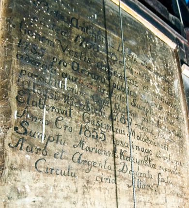 Zdjęcie nr 16: Kościół drewniany, orientowany, z dwuczęściowym korpusem: od wschodu jednonawowym, od zachodu trójnawowym; z prezbiterium zamkniętym trójbocznie, przy którym zakrystia od północy, z przybudówką od południa i dwiema wieżami od zachodu. Od wschodu chór muzyczny wbudowany pomiędzy wieże. Kościół wzniesiono w konstrukcji zrębowej, wieże w słupowo-ramowej, ściany oszalowane pionowym listwowaniem. 
Ściany prezbiterium i wschodniej części korpusu podzielone pseudokolumnami, zachodnia część podzielona kolumnami dźwigającymi architraw. Prezbiterium oddziela półokrągły łuk tęczowy; wschodnią i zachodnią część nawy łuk spłaszczony. Wschodnią część nawy oraz nawy boczne części zachodniej przekrywa płaski strop, zachodnią pozorne sklepienie zwierciadlane. Ściany oraz stropy pokryte polichromią figuralną, ornamentalną oraz roślinną: w prezbiterium namalowano wizerunek Ukrzyżowanego Chrystusa, przed łukiem tęczowym Matkę Boską w otoczeniu tajemnic różańcowych. Strop nawy imituje gwiaździste niebo. Posadzka kamienna. Wejście główne od zachodu, dwoje drzwi spod wież, kolejne od południa, przez przedsionek (babiniec), do zakrystii prowadzi portal zamknięty łukiem nadwieszonym. Cztery okna w prezbiterium o wykroju prostokątnym zamkniętym łukiem nadwieszonym, cztery we wschodniej części nawy o takim samym kształcie, cztery w zachodniej części zamknięte podwójnym łukiem kotarowym, dwa w zakrystii, południowej przybudówce, po dwa wysokie, wąskie okna w wieżach. Fasada dwuwieżowa, trójosiowa, trójkondygnacyjna. Przed wejściem kruchta zwieńczona dachem dwuspadowym, do której prowadzą dwuskrzydłowe drzwi w kształcie prostokątów, ściany boczne przeprute oknami. Powyżej dwie gładkie kondygnacje przedzielone dachem pulpitowym. Wieże trójkondygnacyjne, w dolnej kondygnacji drzwi, w wyższej okna w kształcie stojących prostokątów zamkniętych łukiem ostrym z wyciętym od dołu fragmentem pięcioliścia, powyżej ażurowa koronka. Ostatnią kondygnację tworzy izbica z nadwieszonym gankiem zamkniętym łukami spłaszczonymi. Od zewnątrz wyraźny podział na bryły, ściany gładkie. Każdą część przykrywa gontowy dach dwuspadowy, wspólny dla prezbiterium i starszej części, osobny dla nowszej części nawy; wieże nakryte hełmami namiotowymi, na kalenicy nawy baniasta wieżyczka na sygnaturkę z latarnią.  