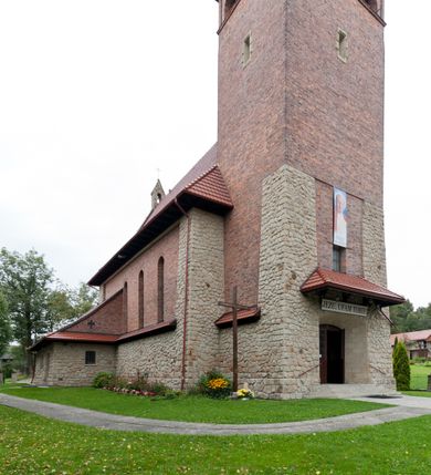 Zdjęcie nr 2: Kościół jest budowlą orientowaną, założoną na planie wydłużonego prostokąta, murowaną, jednonawową z prezbiterium i zakrystią (od północy). Prezbiterium jest węższe od nawy, zamknięte wielobocznie, oddziela je tęcza o łuku półkolistym. Od zachodu chór zamknięty balustradą załamaną trójbocznie i wysuniętą przed lico w części środkowej, dekorowaną płycinami z wicią roślinną. Ściany wnętrza gładkie, brak podziałów pionowych, poziomy podział tworzą przy ziemi nisze zamknięte łukiem odcinkowym; dół ścian wyłożony drewnianą boazerią. Ściany przeprute oknami – prezbiterium dwoma, nawa ośmioma w kształcie stojącego prostokąta zamkniętego łukiem półkolistym; większość wypełniają witraże. Cztery okna w zakrystii. Główne wejście przez korpus wieżowy od zachodu, drugie od zakrystii. Elewacje kościoła są gładkie, górne partie z cegieł, dolne oraz naroża podkreślone okładziną kamienną. Wokół, poniżej partii okien kapnik. Wieża z wejściem umieszczonym w glifie w kształcie stojącego prostokąta zamkniętego łukiem odcinkowym, chronionym daszkiem, ponad którym niewielkie okno. W górnej partii z każdej strony małe okno, pod dachem arkady zamknięte półkoliście, po trzy na każdą stronę. Środkowa arkada ściany frontowej przysłonięta tarczą zegara. Dach nawy dwuspadowy, prezbiterium i zakrystii wieloboczny, ponad nawą kamienna wieżyczka na sygnaturkę, wieża przekryta hełmem namiotowym. Od zewnątrz, na wschodniej ścianie prezbiterium figura ukrzyżowanego Jezusa. Najcenniejszym zabytkiem kościoła jest siedemnastowieczny ołtarz główny, który w poprzedniej budowli stanowił ołtarz boczny. Polichromię zaprojektowała Jadwiga Rymar z Krakowa.