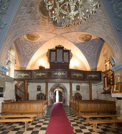 Zdjęcie nr 6: Kościół położony jest na wzniesieniu, obwiedziony dookoła niskim murem. Świątynia murowana, orientowana, jednonawowa na planie prostokątnej nawy z węższym prezbiterium zamkniętym półkoliście, z wieżą od zachodu; przykryty wysokim dwuspadowym dachem, z sygnaturką nad prezbiterium. Wieża czworoboczna, w przyziemiu mieszcząca kruchtę, wyżej przechodząca w ośmiobok, zwieńczona stylizowanym na gotycki, iglicowym, pokrytym blachą hełmem, flankowanym trójkątnymi szczycikami. Od południa kościoła usytuowana jest druga kruchta z kamiennym portalem, a od północy zakrystia z dodatkowym pomieszczeniem na paramenty liturgiczne, nad nimi empora. Prezbiterium oraz nawę obejmuje z zewnątrz sześć wysokich skarp. Wewnątrz podziały architektoniczne wydzielają przyścienne filary w nawie z silnie wysuniętym do wnętrza łukiem tęczy. Prezbiterium oraz nawę oświetla pięć wysokich okien, zamkniętych półkoliście, usytuowanych od południa. Portal główny wykonany z wapienia pińczowskiego o typie arkadowym z charakterystycznym układem kamiennych ciosów dźwiga boniowany łuk archiwolty. Nad nim trójkątny przyczółek, silnie wysunięty przed lico ściany, ujęty dookoła wydatnym, profilowanym gzymsem z kartuszem w polu z herbami: Lubicz, Leliwa, Junosza i Rawicz oraz inicjałami „ALDL” i datą „An[n]o D[omi]ni 1623”. Portal południowy z wapienia jurajskiego o wykroju zbliżonym do ostrołukowego (krzywo wycięty). Natomiast portal do zakrystii o renesansowej budowie i dekoracji. Nawa sklepiona krzyżowo-kolebkowo.
Do zewnętrznej, południowej ściany kościoła dostawiony jest pomnik nagrobny hrabiego Jakuba z Granowa i Eleonory z Dembowskich Wodzickich.