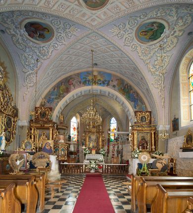 Zdjęcie nr 16: Kościół położony jest na wzniesieniu, obwiedziony dookoła niskim murem. Świątynia murowana, orientowana, jednonawowa na planie prostokątnej nawy z węższym prezbiterium zamkniętym półkoliście, z wieżą od zachodu; przykryty wysokim dwuspadowym dachem, z sygnaturką nad prezbiterium. Wieża czworoboczna, w przyziemiu mieszcząca kruchtę, wyżej przechodząca w ośmiobok, zwieńczona stylizowanym na gotycki, iglicowym, pokrytym blachą hełmem, flankowanym trójkątnymi szczycikami. Od południa kościoła usytuowana jest druga kruchta z kamiennym portalem, a od północy zakrystia z dodatkowym pomieszczeniem na paramenty liturgiczne, nad nimi empora. Prezbiterium oraz nawę obejmuje z zewnątrz sześć wysokich skarp. Wewnątrz podziały architektoniczne wydzielają przyścienne filary w nawie z silnie wysuniętym do wnętrza łukiem tęczy. Prezbiterium oraz nawę oświetla pięć wysokich okien, zamkniętych półkoliście, usytuowanych od południa. Portal główny wykonany z wapienia pińczowskiego o typie arkadowym z charakterystycznym układem kamiennych ciosów dźwiga boniowany łuk archiwolty. Nad nim trójkątny przyczółek, silnie wysunięty przed lico ściany, ujęty dookoła wydatnym, profilowanym gzymsem z kartuszem w polu z herbami: Lubicz, Leliwa, Junosza i Rawicz oraz inicjałami „ALDL” i datą „An[n]o D[omi]ni 1623”. Portal południowy z wapienia jurajskiego o wykroju zbliżonym do ostrołukowego (krzywo wycięty). Natomiast portal do zakrystii o renesansowej budowie i dekoracji. Nawa sklepiona krzyżowo-kolebkowo.
Do zewnętrznej, południowej ściany kościoła dostawiony jest pomnik nagrobny hrabiego Jakuba z Granowa i Eleonory z Dembowskich Wodzickich.