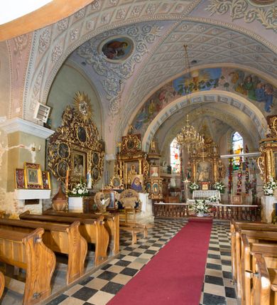 Zdjęcie nr 5: Kościół położony jest na wzniesieniu, obwiedziony dookoła niskim murem. Świątynia murowana, orientowana, jednonawowa na planie prostokątnej nawy z węższym prezbiterium zamkniętym półkoliście, z wieżą od zachodu; przykryty wysokim dwuspadowym dachem, z sygnaturką nad prezbiterium. Wieża czworoboczna, w przyziemiu mieszcząca kruchtę, wyżej przechodząca w ośmiobok, zwieńczona stylizowanym na gotycki, iglicowym, pokrytym blachą hełmem, flankowanym trójkątnymi szczycikami. Od południa kościoła usytuowana jest druga kruchta z kamiennym portalem, a od północy zakrystia z dodatkowym pomieszczeniem na paramenty liturgiczne, nad nimi empora. Prezbiterium oraz nawę obejmuje z zewnątrz sześć wysokich skarp. Wewnątrz podziały architektoniczne wydzielają przyścienne filary w nawie z silnie wysuniętym do wnętrza łukiem tęczy. Prezbiterium oraz nawę oświetla pięć wysokich okien, zamkniętych półkoliście, usytuowanych od południa. Portal główny wykonany z wapienia pińczowskiego o typie arkadowym z charakterystycznym układem kamiennych ciosów dźwiga boniowany łuk archiwolty. Nad nim trójkątny przyczółek, silnie wysunięty przed lico ściany, ujęty dookoła wydatnym, profilowanym gzymsem z kartuszem w polu z herbami: Lubicz, Leliwa, Junosza i Rawicz oraz inicjałami „ALDL” i datą „An[n]o D[omi]ni 1623”. Portal południowy z wapienia jurajskiego o wykroju zbliżonym do ostrołukowego (krzywo wycięty). Natomiast portal do zakrystii o renesansowej budowie i dekoracji. Nawa sklepiona krzyżowo-kolebkowo.
Do zewnętrznej, południowej ściany kościoła dostawiony jest pomnik nagrobny hrabiego Jakuba z Granowa i Eleonory z Dembowskich Wodzickich.