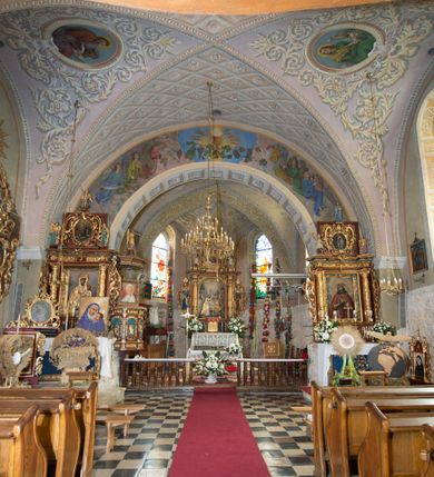 Zdjęcie nr 17: Kościół położony jest na wzniesieniu, obwiedziony dookoła niskim murem. Świątynia murowana, orientowana, jednonawowa na planie prostokątnej nawy z węższym prezbiterium zamkniętym półkoliście, z wieżą od zachodu; przykryty wysokim dwuspadowym dachem, z sygnaturką nad prezbiterium. Wieża czworoboczna, w przyziemiu mieszcząca kruchtę, wyżej przechodząca w ośmiobok, zwieńczona stylizowanym na gotycki, iglicowym, pokrytym blachą hełmem, flankowanym trójkątnymi szczycikami. Od południa kościoła usytuowana jest druga kruchta z kamiennym portalem, a od północy zakrystia z dodatkowym pomieszczeniem na paramenty liturgiczne, nad nimi empora. Prezbiterium oraz nawę obejmuje z zewnątrz sześć wysokich skarp. Wewnątrz podziały architektoniczne wydzielają przyścienne filary w nawie z silnie wysuniętym do wnętrza łukiem tęczy. Prezbiterium oraz nawę oświetla pięć wysokich okien, zamkniętych półkoliście, usytuowanych od południa. Portal główny wykonany z wapienia pińczowskiego o typie arkadowym z charakterystycznym układem kamiennych ciosów dźwiga boniowany łuk archiwolty. Nad nim trójkątny przyczółek, silnie wysunięty przed lico ściany, ujęty dookoła wydatnym, profilowanym gzymsem z kartuszem w polu z herbami: Lubicz, Leliwa, Junosza i Rawicz oraz inicjałami „ALDL” i datą „An[n]o D[omi]ni 1623”. Portal południowy z wapienia jurajskiego o wykroju zbliżonym do ostrołukowego (krzywo wycięty). Natomiast portal do zakrystii o renesansowej budowie i dekoracji. Nawa sklepiona krzyżowo-kolebkowo.
Do zewnętrznej, południowej ściany kościoła dostawiony jest pomnik nagrobny hrabiego Jakuba z Granowa i Eleonory z Dembowskich Wodzickich.