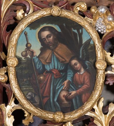 Zdjęcie nr 12: Ołtarz przyścienny, niearchitektoniczny. Mensa prostopadłościenna, kamienna, wyniesiona na dwóch wysokich stopniach. Antepedium w formie malowanego na płótnie obrazu w złoconej, akantowej ramie. W centrum medalion z przedstawieniem narzędzi stolarskich: piły, młotka, siekierki, ręcznego wiertła, dłuta oraz gałązki białej lilii i pałki wodnej umieszczony na tle dekorowanym stylizowaną, przeplatającą się wicią roślinną. Retabulum drewniane o strukturze utworzonej z suchego akantu, pomiędzy który wplecione są obrazy. W predelli obraz w kształcie leżącego owalu z przedstawieniem św. Rozalii. W polu głównym ołtarza obraz w kształcie stojącego prostokąta w złoconej, akantowej ramie, z przedstawieniem Zwiastowania, a na zasuwie św. Józefa z Dzieciątkiem. Po bokach flankowany przez dwie pary obrazów w formie medalionów, ujętych złoconymi ramami. Po lewej stronie, od dołu: św. Helena i św. Sebastian, a po prawej, od dołu: św. Barbara i św. Roch. W zwieńczeniu, na osi obraz przedstawiający św. Franciszka umieszczony w analogicznej ramie. U szczytu płaskorzeźbione przedstawienie Boga Ojca w otoczeniu uskrzydlonych główek anielskich na tle srebrzonych obłoków oraz złoconej, promienistej glorii. Struktura malowana na ciemny brąz, ornamenty złocone i srebrzone. 

