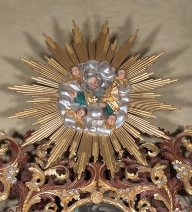 Zdjęcie nr 10: Ołtarz przyścienny, niearchitektoniczny. Mensa prostopadłościenna, kamienna, wyniesiona na dwóch wysokich stopniach. Antepedium w formie malowanego na płótnie obrazu w złoconej, akantowej ramie. W centrum medalion z przedstawieniem narzędzi stolarskich: piły, młotka, siekierki, ręcznego wiertła, dłuta oraz gałązki białej lilii i pałki wodnej umieszczony na tle dekorowanym stylizowaną, przeplatającą się wicią roślinną. Retabulum drewniane o strukturze utworzonej z suchego akantu, pomiędzy który wplecione są obrazy. W predelli obraz w kształcie leżącego owalu z przedstawieniem św. Rozalii. W polu głównym ołtarza obraz w kształcie stojącego prostokąta w złoconej, akantowej ramie, z przedstawieniem Zwiastowania, a na zasuwie św. Józefa z Dzieciątkiem. Po bokach flankowany przez dwie pary obrazów w formie medalionów, ujętych złoconymi ramami. Po lewej stronie, od dołu: św. Helena i św. Sebastian, a po prawej, od dołu: św. Barbara i św. Roch. W zwieńczeniu, na osi obraz przedstawiający św. Franciszka umieszczony w analogicznej ramie. U szczytu płaskorzeźbione przedstawienie Boga Ojca w otoczeniu uskrzydlonych główek anielskich na tle srebrzonych obłoków oraz złoconej, promienistej glorii. Struktura malowana na ciemny brąz, ornamenty złocone i srebrzone. 

