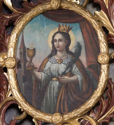 Zdjęcie nr 1: Obraz w kształcie owalu z przedstawieniem św. Barbary. W centrum kompozycji święta ukazana w półpostaci, zwrócona delikatnie w prawo z kielichem w prawej dłoni i  palmą męczeństwa w lewej. Twarz okrągła o jasnej karnacji, okolona ciemnobrązowymi i długimi włosami, nos długi i prosty, drobne usta. Wokół głowy złoty i kolisty nimb, na niej korona otwarta. Ubrana jest w białą suknię przepasaną złotym pasem, ozdobioną na dekolcie złotą broszką oraz brązowy płaszcz. Po lewej stronie wysoka wieża, nakryta czerwonym dachem i opięta szkarpami. W górnej części kompozycji i z prawej strony podwieszona i udrapowana ciemnoczerwona tkanina. W tle błękitne niebo. Kolorystyka przygaszona. Rama złocona w formie wieńca z liści wawrzynu zdobiona czterema małymi różami.
