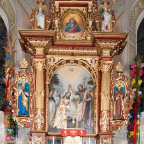 Zdjęcie nr 1: Nastawa ołtarzowa architektoniczna, jednoosiowa, dwukondygnacyjna, na cokole. Ołtarz murowany z kamienną mensą. Na lewym boku ołtarza drewniana wnęka na oleje święte z inskrypcją „OLEA SACRA”. Antepedium w formie leżącego prostokąta w profilowanej ramie, pole kompozycyjne dekorowane dookoła rzędem kolorowych rombów. W polu antepedium znajduje się haftowane koralikami przedstawienie gorejącego serca w koronie cierniowej z zatkniętym u góry krzyżykiem łacińskim. Tabernakulum w formie prostopadłościennej skrzynki. Drzwiczki dwuskrzydłowe, odlewane, w polach przedstawienie wici roślinnej oraz litery alfa i omega. Ściany boczne zdobione kaboszonem i ornamentem małżowinowo-chrząstkowym. Nastawa ustawiona jest na cokole. Pierwsza kondygnacja ujęta parą kolumn. Podpory dźwigają pełne belkowanie wyłamane nad polem środkowym, zamknięte silnie wysuniętym gzymsem. Pole obrazowe w formie arkady z obrazem przedstawiającym Chrzest Chrystusa, na zasuwie obraz Matki Boskiej Nieustającej Pomocy. Kondygnacja ujęta jest uszami z płytkimi niszami dla figur św. Piotra po lewej stronie i św. Pawła po prawej, zwieńczonymi akroterionami utworzonymi z ornamentu małżowinowo-chrząstkowego. Druga kondygnacja ustawiona jest na cokole, ujęta pilastrami hermowymi o kapitelach korynckich, dźwigającymi pełne belkowanie z silnie wystającym gzymsem. Pole obrazowe w formie owalu z przedstawieniem Boga Ojca i Gołębicy Ducha Świętego. Po bokach drugiej kondygnacji znajdują się nisze z figurami św. Stanisława po prawej stronie i nierozpoznanego świętego biskupa po lewej. Ołtarz zwieńczony  jest cokołem z figurą św. Wojciecha.

Cokoły kolumn pierwszej kondygnacji dekorowane są z frontu uskrzydlonymi główkami anielskimi, na zewnętrznych bokach kartuszami z tarczą herbową czteropolową z herbami: Lubicz, Leliwa, Junosza i Rawicz; od wewnątrz ornamentem małżowinowym z chrząstką i kaboszonem. Cokoły kolumn pierwszej kondygnacji w jednej trzeciej wysokości zdobione są ornamentem małżowinowym z kaboszonami, powyżej trzon otoczony jest podwiązaną tkaniną. W polu środkowym w przyłuczach arkady umieszczone są uskrzydlone główki anielskie; węgary od wewnątrz dekorowane są kaboszonami z małżowiną oraz rozetami, podłucze zaś rozetami. Fryz zdobiony jest kaboszonami z małżowiną; a gzyms dekoracją roślinno-geometryczną. Uszy z niszami utworzone są z ornamentu małżowinowo-chrząstkowego. Cokół drugiej kondygnacji dekorowany jest ornamentem małżowinowo-chrząstkowym i kaboszonem, a trzony kolumn utworzone są uskrzydlonych główek anielskich o stylizowanych na woluty skrzydłach. W czterech narożach pola obrazowego umieszczone są uskrzydlone główki anielskie. W polu fryzu znajduje się uskrzydlona główka anielska; gzyms dekorowany jest ornamentem roślinnym. Kondygnacja ujęta jest uszami z płaskiej małżowiny. Gzyms zakończony ażurowym ornamentem małżowinowo-chrząstkowym. Nisze z figurami otoczone są ornamentem małżowinowo-chrząstkowym i zwieńczone cokołami z palmetą. 
Nastawa polichromowana na czerwono z zielonymi i czarnymi elementami. Ornamentyka i kolumny złocone, kaboszony srebrzone.