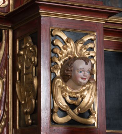 Zdjęcie nr 9: Nastawa ołtarzowa architektoniczna, jednoosiowa, dwukondygnacyjna, na cokole. Ołtarz murowany z kamienną mensą. Na lewym boku ołtarza drewniana wnęka na oleje święte z inskrypcją „OLEA SACRA”. Antepedium w formie leżącego prostokąta w profilowanej ramie, pole kompozycyjne dekorowane dookoła rzędem kolorowych rombów. W polu antepedium znajduje się haftowane koralikami przedstawienie gorejącego serca w koronie cierniowej z zatkniętym u góry krzyżykiem łacińskim. Tabernakulum w formie prostopadłościennej skrzynki. Drzwiczki dwuskrzydłowe, odlewane, w polach przedstawienie wici roślinnej oraz litery alfa i omega. Ściany boczne zdobione kaboszonem i ornamentem małżowinowo-chrząstkowym. Nastawa ustawiona jest na cokole. Pierwsza kondygnacja ujęta parą kolumn. Podpory dźwigają pełne belkowanie wyłamane nad polem środkowym, zamknięte silnie wysuniętym gzymsem. Pole obrazowe w formie arkady z obrazem przedstawiającym Chrzest Chrystusa, na zasuwie obraz Matki Boskiej Nieustającej Pomocy. Kondygnacja ujęta jest uszami z płytkimi niszami dla figur św. Piotra po lewej stronie i św. Pawła po prawej, zwieńczonymi akroterionami utworzonymi z ornamentu małżowinowo-chrząstkowego. Druga kondygnacja ustawiona jest na cokole, ujęta pilastrami hermowymi o kapitelach korynckich, dźwigającymi pełne belkowanie z silnie wystającym gzymsem. Pole obrazowe w formie owalu z przedstawieniem Boga Ojca i Gołębicy Ducha Świętego. Po bokach drugiej kondygnacji znajdują się nisze z figurami św. Stanisława po prawej stronie i nierozpoznanego świętego biskupa po lewej. Ołtarz zwieńczony  jest cokołem z figurą św. Wojciecha.

Cokoły kolumn pierwszej kondygnacji dekorowane są z frontu uskrzydlonymi główkami anielskimi, na zewnętrznych bokach kartuszami z tarczą herbową czteropolową z herbami: Lubicz, Leliwa, Junosza i Rawicz; od wewnątrz ornamentem małżowinowym z chrząstką i kaboszonem. Cokoły kolumn pierwszej kondygnacji w jednej trzeciej wysokości zdobione są ornamentem małżowinowym z kaboszonami, powyżej trzon otoczony jest podwiązaną tkaniną. W polu środkowym w przyłuczach arkady umieszczone są uskrzydlone główki anielskie; węgary od wewnątrz dekorowane są kaboszonami z małżowiną oraz rozetami, podłucze zaś rozetami. Fryz zdobiony jest kaboszonami z małżowiną; a gzyms dekoracją roślinno-geometryczną. Uszy z niszami utworzone są z ornamentu małżowinowo-chrząstkowego. Cokół drugiej kondygnacji dekorowany jest ornamentem małżowinowo-chrząstkowym i kaboszonem, a trzony kolumn utworzone są uskrzydlonych główek anielskich o stylizowanych na woluty skrzydłach. W czterech narożach pola obrazowego umieszczone są uskrzydlone główki anielskie. W polu fryzu znajduje się uskrzydlona główka anielska; gzyms dekorowany jest ornamentem roślinnym. Kondygnacja ujęta jest uszami z płaskiej małżowiny. Gzyms zakończony ażurowym ornamentem małżowinowo-chrząstkowym. Nisze z figurami otoczone są ornamentem małżowinowo-chrząstkowym i zwieńczone cokołami z palmetą. 
Nastawa polichromowana na czerwono z zielonymi i czarnymi elementami. Ornamentyka i kolumny złocone, kaboszony srebrzone.