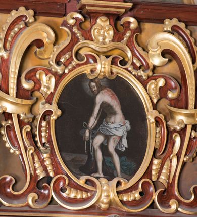 Zdjęcie nr 5: Ołtarz architektoniczny, jednoosiowy, jednokondygnacyjny ze zwieńczeniem. Ołtarz murowany, prostopadłościenny z kamienną mensą. Antepedium drewniane, w polu którego ozdobny, płaskorzeźbiony monogram Chrystusa na niebieskim tle wraz z dekoracją ornamentalną w narożach pola. Pole ujęte ozdobną ramą z płaskorzeźbionym ornamentem z wici roślinnej na jasnoniebieskim tle. Drewniane retabulum ustawione na cokole. W polu obraz z przedstawieniem Modlitwy w Ogrójcu w kształcie leżącego prostokąta o krótszych bokach zakończonych łukiem nadwieszonym. Nastawa flankowana parą kolumn podtrzymujących wyłamane nad osią główną belkowanie. W polu głównym obraz Ecce Homo, a na zasuwie obraz św. Antoniego Padewskiego. Zwieńczenie w formie owalu ujętego ażurową dekoracją formowaną z ornamentu małżowinowo-chrząstkowego na tle kwadratowej ramy. W polu obraz Chrystusa u słupa, po bokach figury, po lewej św. Mikołaja, po prawej św. Doroty, na szczycie figura św. Józefa. Partie cokołów ozdobione płycinami z uskrzydlonymi główkami aniołów w polu, po bokach dekorowane ornamentem małżowinowo-chrząstkowym. Zasadnicza część nastawy ujęta po bokach uszami z ornamentem o formach małżowinowo-chrząstkowych, z czego prawy złożony, dostosowany do południowego filaru kościoła. Trzony kolumn w dolnej partii ozdobione kartuszami o fantazyjnych wycięciach z motywami kaboszonów, w górnej partii pokryte dekoracją w formie wici winnej latorośli. W partii fryzu oraz pod gzymsem ornamentyka roślinna. Pośrodku belkowania motyw dekoracyjnego spływu z uskrzydloną główką aniołka z podwiązaną chustą pod szyją. Pole środkowe w formie prostokątnej wnęki ujętej profilowanymi ramami z czego wewnętrzna ozdobiona ornamentem małżowinowo-chrząstkowym. Polichromia struktury ołtarza utrzymana w odcieniach ciemnego brązu i czerwieni, partie w tle ornamentów niebieskie. Ornamentyka i elementy detalu architektonicznego złocone i srebrzone. 

