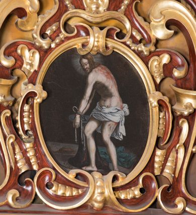 Zdjęcie nr 1: Obraz w kształcie owalu. Pośrodku kompozycji ukazany Chrystus, zwrócony trzy czwarte w prawo o silnie skręconej górnej części ciała w prawo, delikatnie pochylony w dół, z rękami przywiązanymi sznurem do kolumny biczowania. Twarz podłużna z długim i wąskim nosem, wzrokiem skierowanym w dół, okolona krótką brodą oraz długimi i falującymi włosami, spływającymi na plecy. Chrystus ubrany poniżej bioder w białe perizonium przewiązane na lewym boku. Sylwetka szczupła o bladej karnacji, z licznie zaznaczonymi śladami krwi, zwłaszcza w partii pleców i nóg. Wokół głowy Chrystusa biały, świetlisty nimb. W dolnej części kompozycji na ziemi leżą: po lewej bicze, po prawej niebieska suknia. Kolumna biczowania niska, stojąca na okrągłej podstawie i zamknięta od góry okrągłym gzymsem. Tło ciemne, jednolite.