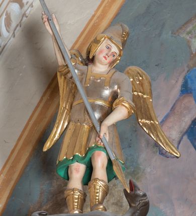 Zdjęcie nr 4: Ołtarz architektoniczny, jednoosiowy, jednokondygnacyjny ze zwieńczeniem. Ołtarz murowany, prostopadłościenny z kamienną mensą. Antepedium drewniane, w polu którego ozdobny, płaskorzeźbiony monogram maryjny na niebieskim tle oraz dekoracja ornamentalna w narożach pola. Pole ujęte ozdobną ramą z płaskorzeźbionym ornamentem z wici roślinnej na jasnoniebieskim tle. Drewniane retabulum ustawione na cokole. W predelli obraz z przedstawieniem Nawiedzenia Najświętszej Marii Panny w kształcie leżącego prostokąta o krótszych bokach zakończonych półkolistym łukiem nadwieszonym. Nastawa flankowana parą kolumn podtrzymujących wyłamane nad osią główną belkowanie. W polu głównym obraz Matki Boskiej Śnieżnej, a na zasuwie obraz Najświętsze Serce Jezusa. Zwieńczenie w formie owalu ujętego dekoracyjną, ażurową ramą formowaną z ornamentu małżowinowo-chrząstkowego na tle kwadratowej ramy. W polu znajduje się obraz „Koronacja Najświętszej Marii Panny”, a po bokach figury, po lewej: św. Archanioła Rafała z Tobiaszem, po prawej: św. Jana Ewangelisty, na szczycie figura św. Michała Archanioła. Partie cokołów ozdobione są ornamentem w formie kartusza o fantazyjnie kształtowanych krawędziach, z motywem kaboszonów pośrodku. Cokoły po zewnętrznej stronie zostały ozdobione ornamentalnym podwieszeniem z motywem małżowinowo-chrząstkowym. Zasadnicza część nastawy ujęta po bokach uszami z ornamentem o formach małżowinowo-chrząstkowych, z czego lewy złożony, dostosowany do północnego filaru kościoła. Trzony kolumn w dolnej partii ozdobione kartuszami o fantazyjnych wycięciach z motywami kaboszonów, w górnej partii pokryte dekoracją w formie wici winnej latorośli. W partii fryzu oraz pod gzymsem ornamentyka roślinna. Pośrodku belkowania motyw dekoracyjnego spływu z uskrzydloną główką aniołka z podwiązaną chustą pod szyją. Pole środkowe w formie prostokątnej wnęki ujętej profilowanymi ramami z czego wewnętrzna ozdobiona ornamentem małżowinowo-chrząstkowym z motywami uskrzydlonych główek aniołków pośrodku każdego boku ramy. Polichromia struktury ołtarza utrzymana w odcieniach ciemnego brązu i bordo, partie w tle ornamentów niebieskie. Ornamentyka i elementy detalu architektonicznego złocone i srebrzone. 