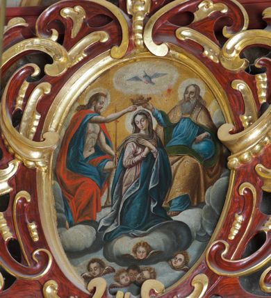 Zdjęcie nr 1: Obraz w kształcie owalu przedstawiający koronację Najświętszej Marii Panny. Pośrodku klęcząca Maria, delikatnie zwrócona w lewo, z rękami skrzyżowanymi na piersiach, z głową zwróconą w prawo. Ma szeroką twarz z wysokim czołem, z małymi ustami, długim nosem i delikatnie przymkniętymi oczami oraz silnie zarumienione policzki. Ubrana jest w długą i różową suknię z długimi rękawami, niebieski płaszcz z jasnobłękitną podszewką oraz jasnobrązowy welon, spod którego widać ciemnobrązowe włosy. Po prawej stronie obrazu znajduje się siedzący Bóg Ojciec, prawą ręką trzymający koronę nad głową Marii, z lewą ręką wspartą na niebieskim globie ziemskim. Twarz o rysach starszego mężczyzny, okolona długą i siwą brodą oraz długimi i siwymi włosami. Ubrany jest w niebieską długą suknię z długimi rękawami oraz złoty płaszcz z zieloną podszewką spięty na piersiach, na brzegach zdobiony perełkowaniem. Po lewej stronie Chrystus ukazany w pozycji siedzącej, zwrócony w lewo, prawą ręką podtrzymujący koronę nad głową Marii, w lewej dzierżący długie berło. Twarz widoczna z prawego profilu, okolona krótką i brązową brodą oraz długimi, falującymi włosami, spływającymi na plecy. Ubrany jest w niebieską szatę, odsłaniającą nagi tors oraz czerwony płaszcz. Wszystkie postacie mają wokół głów białe i koliste nimby. W dolnej części kompozycji na tle bujnych chmur znajdują się uskrzydlone główki aniołków; w górnej części obrazu gołębica Ducha Świętego z rozpostartymi szeroko skrzydłami, od której odchodzą promienie światła, a wokół niej biała, owalna aureola na tle żółtego nieba. 


