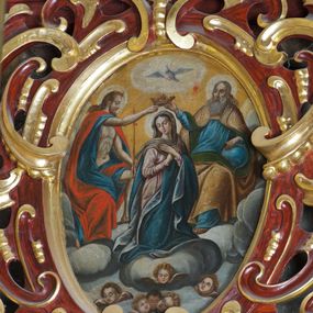 Zdjęcie nr 1: Obraz w kształcie owalu przedstawiający koronację Najświętszej Marii Panny. Pośrodku klęcząca Maria, delikatnie zwrócona w lewo, z rękami skrzyżowanymi na piersiach, z głową zwróconą w prawo. Ma szeroką twarz z wysokim czołem, z małymi ustami, długim nosem i delikatnie przymkniętymi oczami oraz silnie zarumienione policzki. Ubrana jest w długą i różową suknię z długimi rękawami, niebieski płaszcz z jasnobłękitną podszewką oraz jasnobrązowy welon, spod którego widać ciemnobrązowe włosy. Po prawej stronie obrazu znajduje się siedzący Bóg Ojciec, prawą ręką trzymający koronę nad głową Marii, z lewą ręką wspartą na niebieskim globie ziemskim. Twarz o rysach starszego mężczyzny, okolona długą i siwą brodą oraz długimi i siwymi włosami. Ubrany jest w niebieską długą suknię z długimi rękawami oraz złoty płaszcz z zieloną podszewką spięty na piersiach, na brzegach zdobiony perełkowaniem. Po lewej stronie Chrystus ukazany w pozycji siedzącej, zwrócony w lewo, prawą ręką podtrzymujący koronę nad głową Marii, w lewej dzierżący długie berło. Twarz widoczna z prawego profilu, okolona krótką i brązową brodą oraz długimi, falującymi włosami, spływającymi na plecy. Ubrany jest w niebieską szatę, odsłaniającą nagi tors oraz czerwony płaszcz. Wszystkie postacie mają wokół głów białe i koliste nimby. W dolnej części kompozycji na tle bujnych chmur znajdują się uskrzydlone główki aniołków; w górnej części obrazu gołębica Ducha Świętego z rozpostartymi szeroko skrzydłami, od której odchodzą promienie światła, a wokół niej biała, owalna aureola na tle żółtego nieba. 


