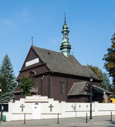 Zdjęcie nr 1: Kościół orientowany, jednonawowy, z węższym, zamkniętym wielobocznie prezbiterium, przy którym od północy prostokątna zakrystia (obecnie skarbiec) od południa prostokątna nowa zakrystia. Przy korpusie od południa i zachodu kruchty. Wewnątrz stropy, w prezbiterium i środkowej części nawy z fasetami; w nawie boczne płaskie odcinki stropu wparte na dwóch słupach. W prezbiterium i nawie na stropach dekoracja geometryczna z listew. Ściany artykułowane pilastrami. Tęcza o wystroju prostokątnym, ujęta przyściennymi filarami. Zewnątrz ściany szalowane deskowaniem na nakładkę, opięte pilastrami. Fasada rozczłonkowana czterema pilastrami wspierającymi gzyms, pośrodku wyłamany nad oknem wchodzącym w pole szczytu. Szczyt trójkątny, w połowie przedzielony gzymsem. Dachy dwuspadowe, nad prezbiterium wielopołaciowy, nad nową zakrystią namiotowy oraz pulpitowe; na kalenicy dachu nawy sygnaturka. Okna prostokątne w profilowanych obramieniach. Portal uszaty, z datą: 1748.