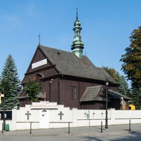 Zdjęcie nr 1: Kościół orientowany, jednonawowy, z węższym, zamkniętym wielobocznie prezbiterium, przy którym od północy prostokątna zakrystia (obecnie skarbiec) od południa prostokątna nowa zakrystia. Przy korpusie od południa i zachodu kruchty. Wewnątrz stropy, w prezbiterium i środkowej części nawy z fasetami; w nawie boczne płaskie odcinki stropu wparte na dwóch słupach. W prezbiterium i nawie na stropach dekoracja geometryczna z listew. Ściany artykułowane pilastrami. Tęcza o wystroju prostokątnym, ujęta przyściennymi filarami. Zewnątrz ściany szalowane deskowaniem na nakładkę, opięte pilastrami. Fasada rozczłonkowana czterema pilastrami wspierającymi gzyms, pośrodku wyłamany nad oknem wchodzącym w pole szczytu. Szczyt trójkątny, w połowie przedzielony gzymsem. Dachy dwuspadowe, nad prezbiterium wielopołaciowy, nad nową zakrystią namiotowy oraz pulpitowe; na kalenicy dachu nawy sygnaturka. Okna prostokątne w profilowanych obramieniach. Portal uszaty, z datą: 1748.