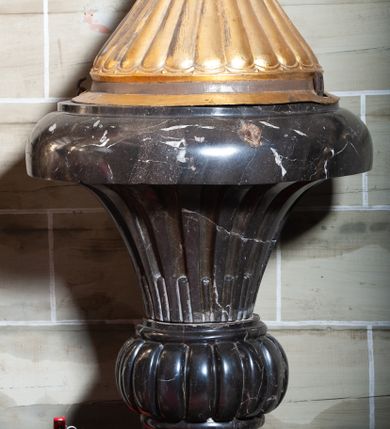 Zdjęcie nr 1: Chrzcielnica posadowiona na szerokiej podstawie na rzucie koła, z trzonem w dolnej części lekko wklęsłym zakończonym puklowanym pierścieniem, z czarą o formie rozchylonego kielicha z regularnymi wgłębieniami i gładkim, zaoblonym brzegiem. Pokrywa miedziana w formie puklowanego stożka, zwieńczonego postumentem z krzyżem. 