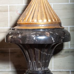 Zdjęcie nr 1: Chrzcielnica posadowiona na szerokiej podstawie na rzucie koła, z trzonem w dolnej części lekko wklęsłym zakończonym puklowanym pierścieniem, z czarą o formie rozchylonego kielicha z regularnymi wgłębieniami i gładkim, zaoblonym brzegiem. Pokrywa miedziana w formie puklowanego stożka, zwieńczonego postumentem z krzyżem.