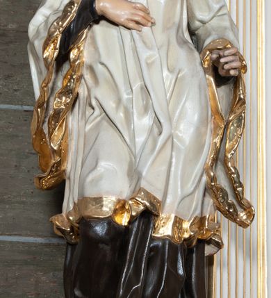 Zdjęcie nr 13: Ołtarz jednoosiowy, jednokondygnacyjny, ze zwieńczeniem. Mensa umieszczona na tumbie zwężającej się ku dołowi, ozdobionej od czoła płyciną prostokątną w złoconym obramieniu, pośrodku ze splecionymi literami imienia Maria. Nastawa flankowana ustawionymi ukośnie czworobocznymi, kanelowanymi filarami, dźwigającymi odcinki pełnego belkowania i gzymsu, przerwanych nad polem środkowym. Na tle filarów umieszczone na konsolach rzeźby: św. Stanisława Kostki (po lewej) i św. Ignacego Loyoli (po prawej). W polu środkowym, nad mensą zawieszony obraz w ozdobnej ramie z przedstawieniem św. Stanisława Kostki w półpostaci; wyżej prostokątna nisza, w której obraz Matki Boskiej z Dzieciątkiem. Zwieńczenie w kształcie aediculi zamkniętej łukiem półkolistym nadwieszonym, w której polu obraz z przedstawieniem św. Józefa w półpostaci. Po bokach, w osiach filarów odcinki przerwanego przyczółka na których rzeźby nagich, uskrzydlonych puttów.  Na gzymsie wieńczącym ołtarz Gołębica Ducha Świętego wśród promieni.