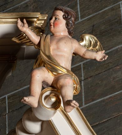 Zdjęcie nr 10: Ołtarz jednoosiowy, jednokondygnacyjny, ze zwieńczeniem. Mensa umieszczona na tumbie zwężającej się ku dołowi, ozdobionej od czoła płyciną prostokątną w złoconym obramieniu, pośrodku ze splecionymi literami imienia Maria. Nastawa flankowana ustawionymi ukośnie czworobocznymi, kanelowanymi filarami, dźwigającymi odcinki pełnego belkowania i gzymsu, przerwanych nad polem środkowym. Na tle filarów umieszczone na konsolach rzeźby: św. Stanisława Kostki (po lewej) i św. Ignacego Loyoli (po prawej). W polu środkowym, nad mensą zawieszony obraz w ozdobnej ramie z przedstawieniem św. Stanisława Kostki w półpostaci; wyżej prostokątna nisza, w której obraz Matki Boskiej z Dzieciątkiem. Zwieńczenie w kształcie aediculi zamkniętej łukiem półkolistym nadwieszonym, w której polu obraz z przedstawieniem św. Józefa w półpostaci. Po bokach, w osiach filarów odcinki przerwanego przyczółka na których rzeźby nagich, uskrzydlonych puttów.  Na gzymsie wieńczącym ołtarz Gołębica Ducha Świętego wśród promieni.